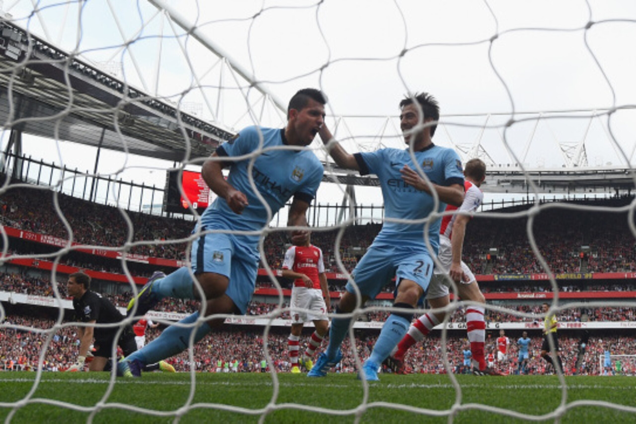 LONDON, ENGLAND - SEPTEMBER 13:  Sergio Aguero of Manchester City celebrates with team-mate David Silva after scoring the first goal during the Barclays Premier League match between Arsenal and Manchester City at Emirates Stadium on September 13, 2014 in 
