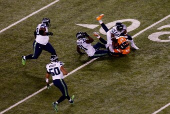 EAST RUTHERFORD, NJ - FEBRUARY 02:  Strong safety Kam Chancellor #31 and cornerback Walter Thurmond #28 of the Seattle Seahawks tackle tight end Julius Thomas #80 of the Denver Broncos during Super Bowl XLVIII at MetLife Stadium on February 2, 2014 in Eas