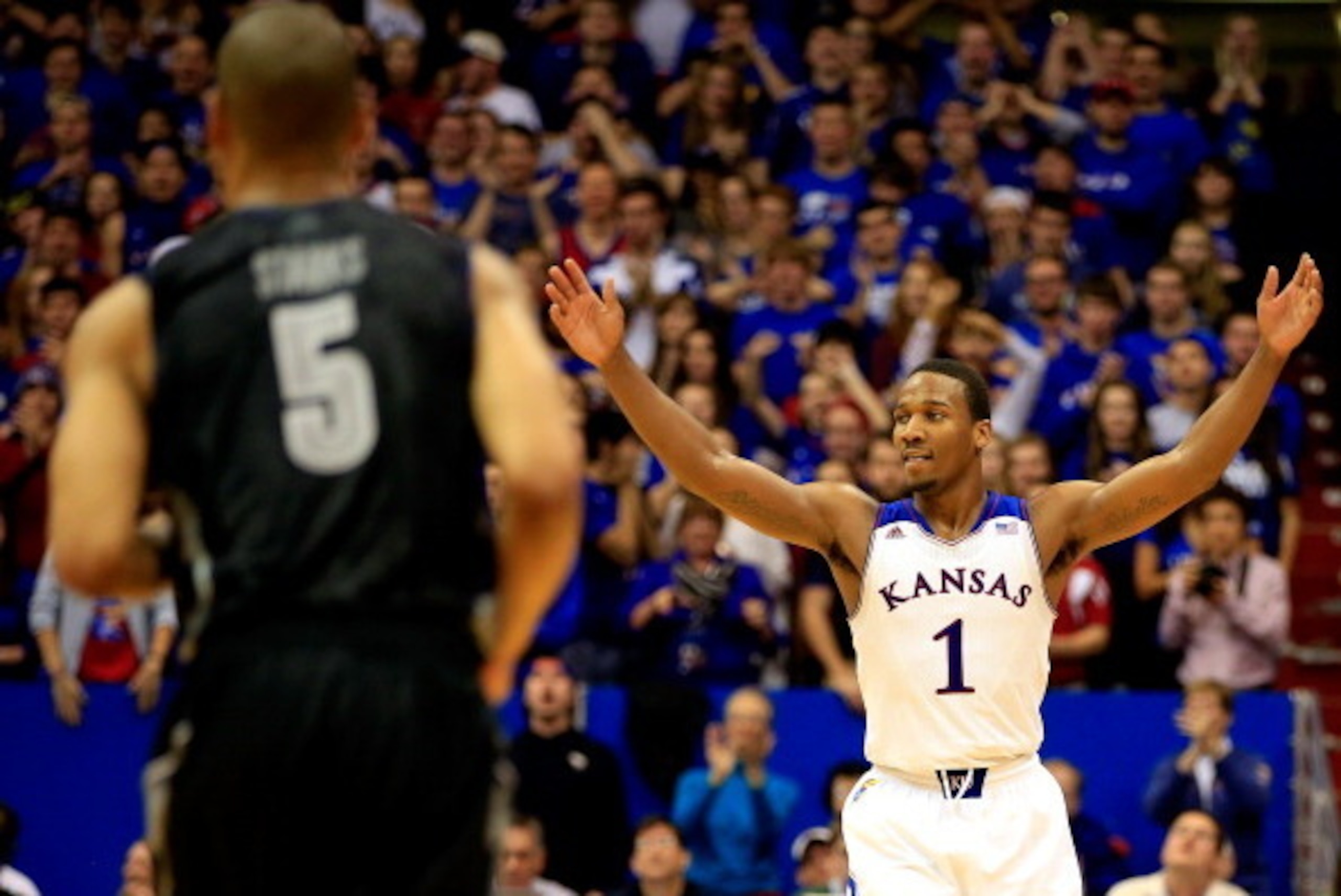 LAWRENCE, KS - DECEMBER 21:  Wayne Selden, Jr. #1 of the Kansas Jayhawks celebrates after scoring as Markel Starks #5 of the Georgetown Hoyas walks back downcourt during the game at Allen Fieldhouse on December 21, 2013 in Lawrence, Kansas.  (Photo by Jam