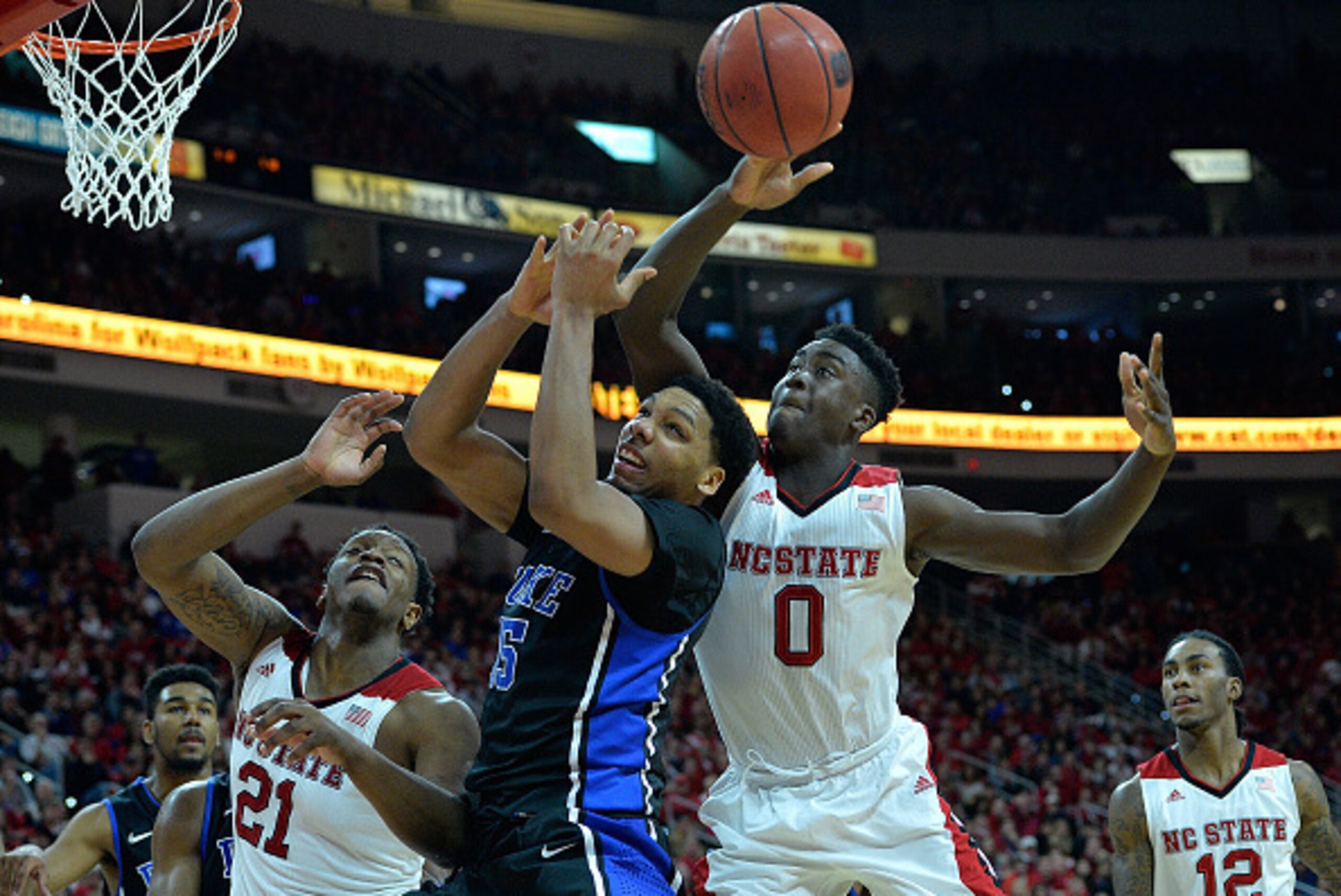 RALEIGH, NC - JANUARY 11: Jahlil Okafor #15 of the Duke Blue Devils battles Beejay Anya #21 and Abdul-Malik Abu #0 of the North Carolina State Wolfpack for a rebound during their game at PNC Arena on January 11, 2015 in Raleigh, North Carolina. North Caro