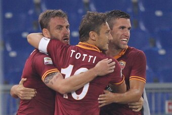 ROME, ITALY - SEPTEMBER 29:  Alessandro Florenzi (not seen) with his team mates Daniele De Rossi (L), Francesco Totti and Kevin Strootman of AS Roma celebrates after scoring the opening goal during the Serie A match between AS Roma and Bologna FC at the S