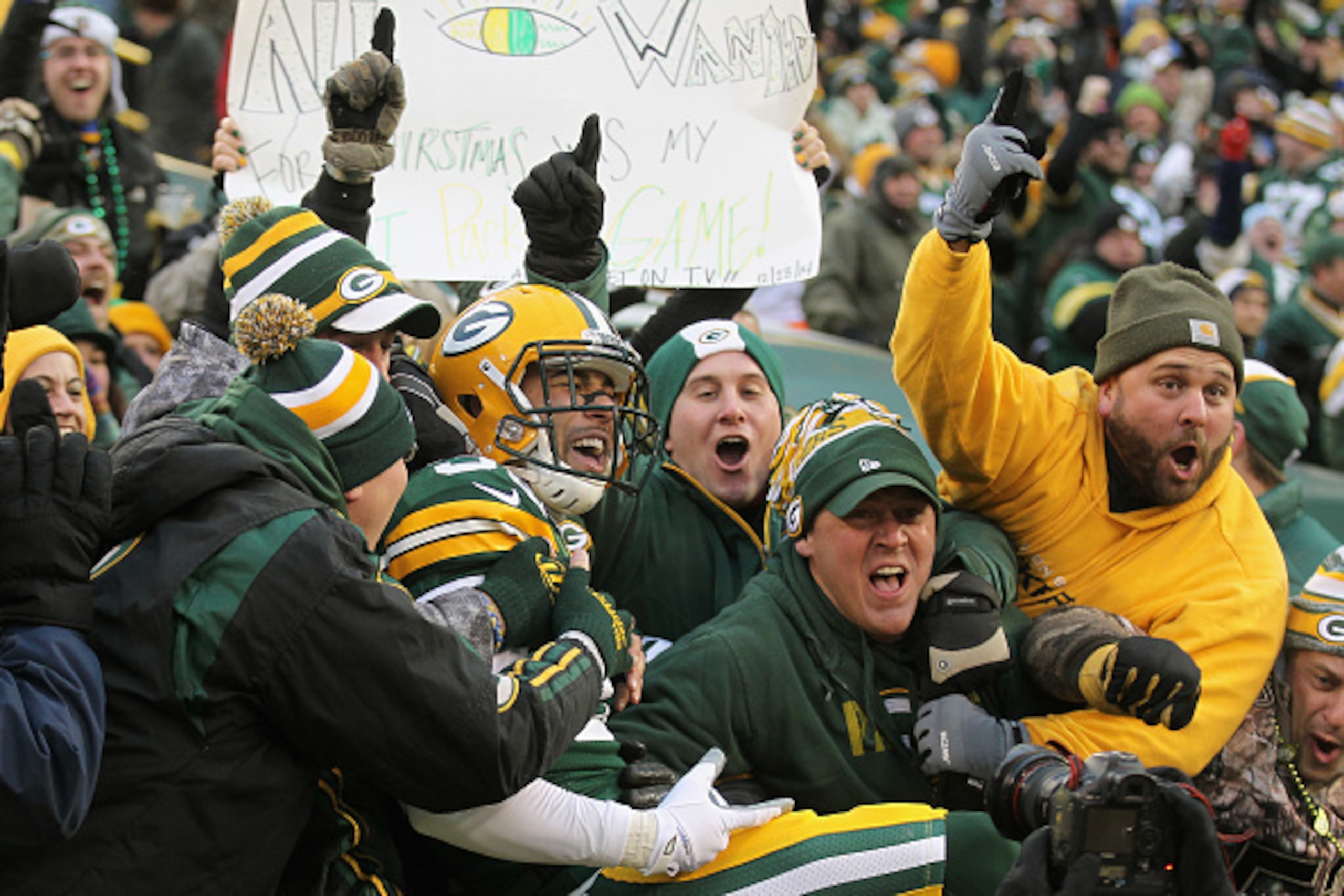 GREEN BAY, WI - DECEMBER 28:  Free safety Micah Hyde #33 of the Green Bay Packers leaps into the crowd after scoring a touchdown on a punt return in the first quarter against the Detroit Lions during the NFL game at Lambeau Field on December 28, 2014 in G