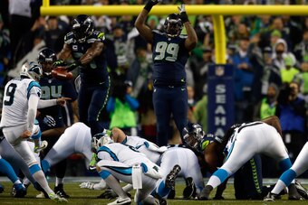 SEATTLE, WA - JANUARY 10:  Kam Chancellor #31 of the Seattle Seahawks blocks Graham Gano #9 of the Carolina Panthers but gets called for roughing the kicker in the second quarter during the 2015 NFC Divisional Playoff game at CenturyLink Field on January