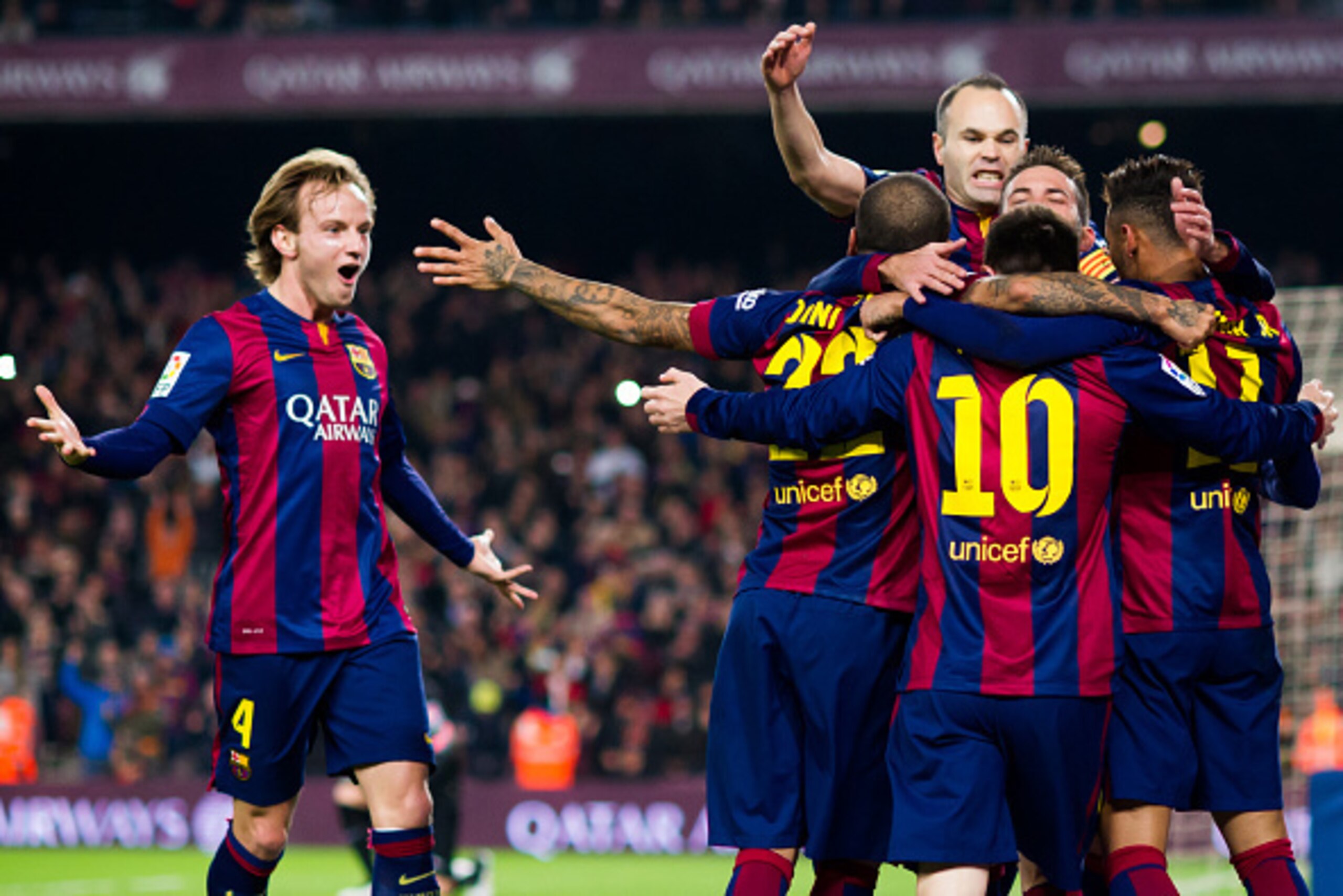 BARCELONA, SPAIN - JANUARY 11: Ivan Rakitic (L) and Andres Iniesta (top) of FC Barcelona celebrate with their team-mates after Neymar Santos Jr scored the opening goal during the La Liga match between FC Barcelona and Club Atletico de Madrid at Camp Nou o