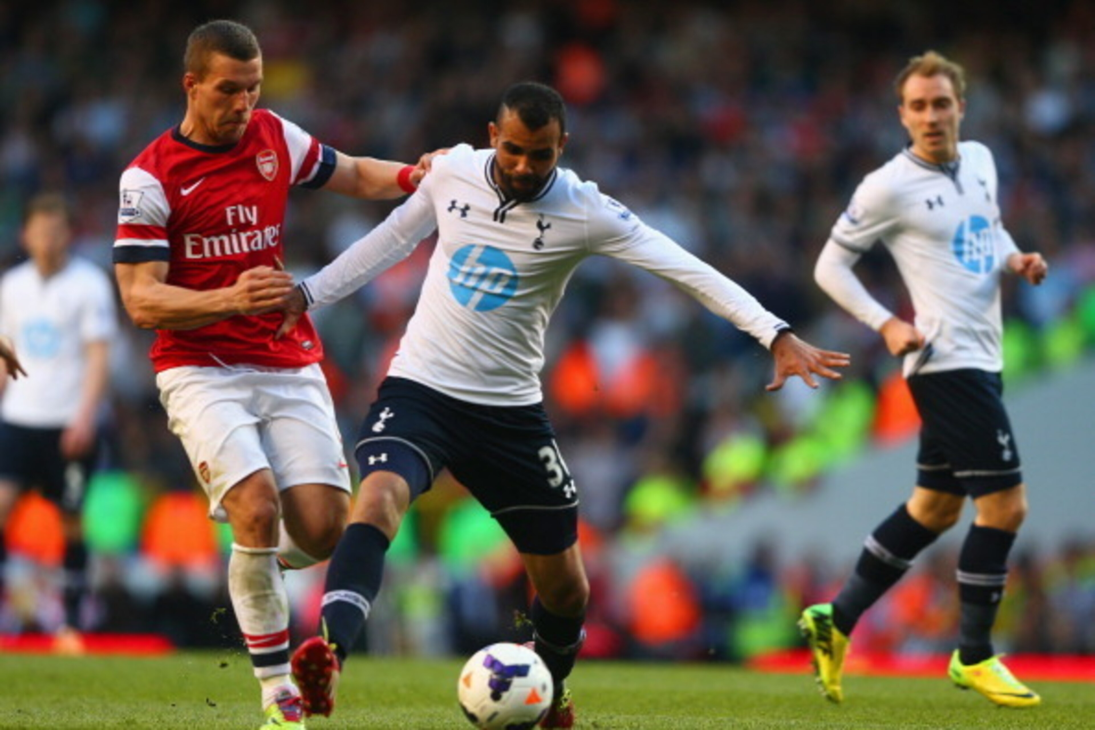 LONDON, ENGLAND - MARCH 16:  Sandro of Tottenham Hotspur and Lukas Podolski of Arsenal competes for the ball during the Barclays Premier League match between Tottenham Hotspur and Arsenal at White Hart Lane on March 16, 2014 in London, England.  (Photo by
