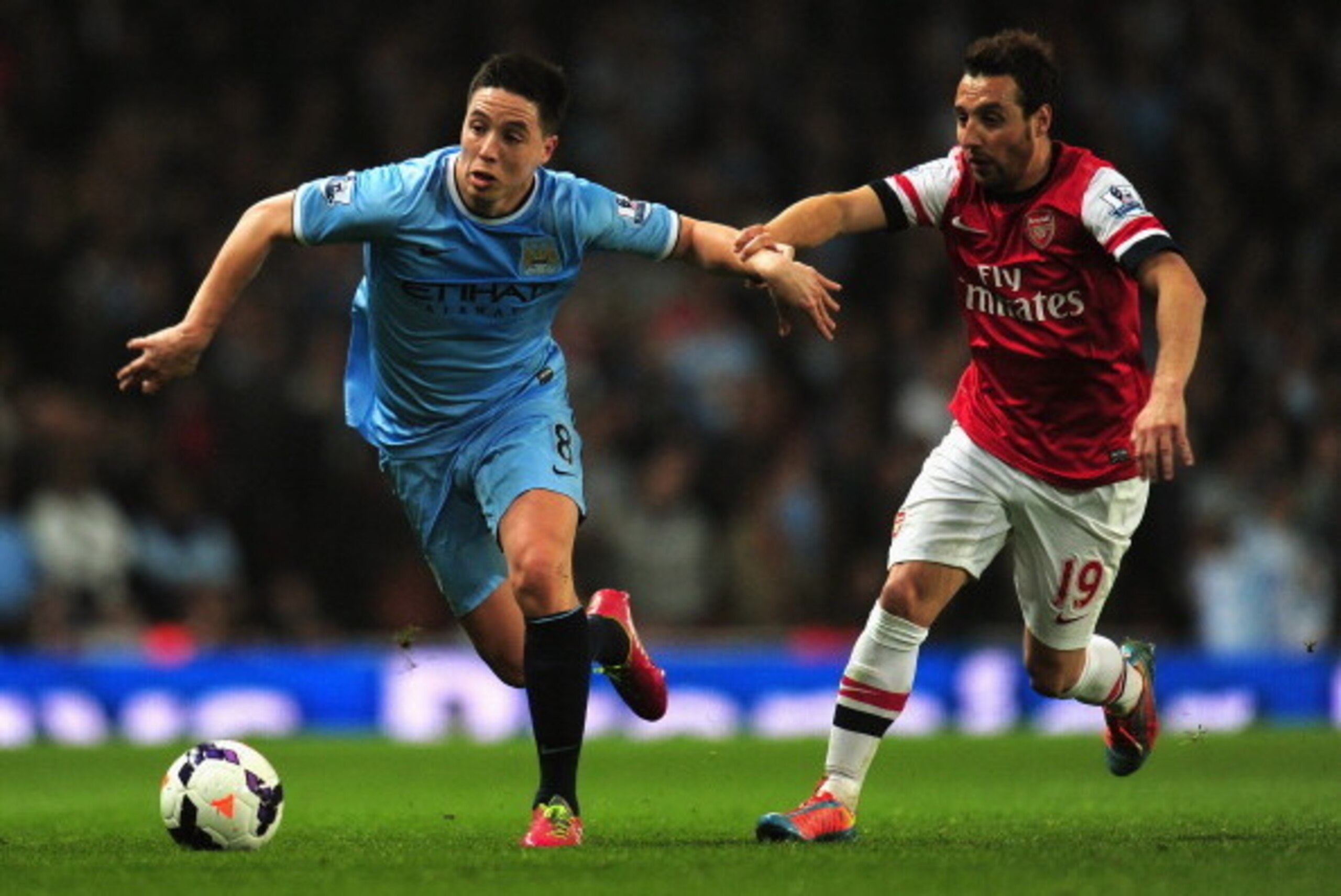 LONDON, ENGLAND - MARCH 29:  Samir Nasri of Manchester City and Santi Cazorla of Arsenal battle for the ball during the Barclays Premier League match between Arsenal and Manchester City at Emirates Stadium on March 29, 2014 in London, England.  (Photo by 