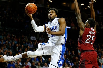NEW YORK, NY - NOVEMBER 21: Justise Winslow #12 of the Duke Blue Devils goes to the basket as Quenton DeCosey #25 of the Temple Owls fdefends in the first half of a game in the Coaches vs Cancer Classic men's basketball tournament at Barclays Center on No