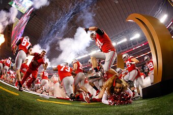 ARLINGTON, TX - JANUARY 12:  A Ohio State Buckeyes cheerleader falls as the Buckeyes run out to the field before the College Football Playoff National Championship Game at AT&T Stadium on January 12, 2015 in Arlington, Texas.  (Photo by Tom Pennington/Get