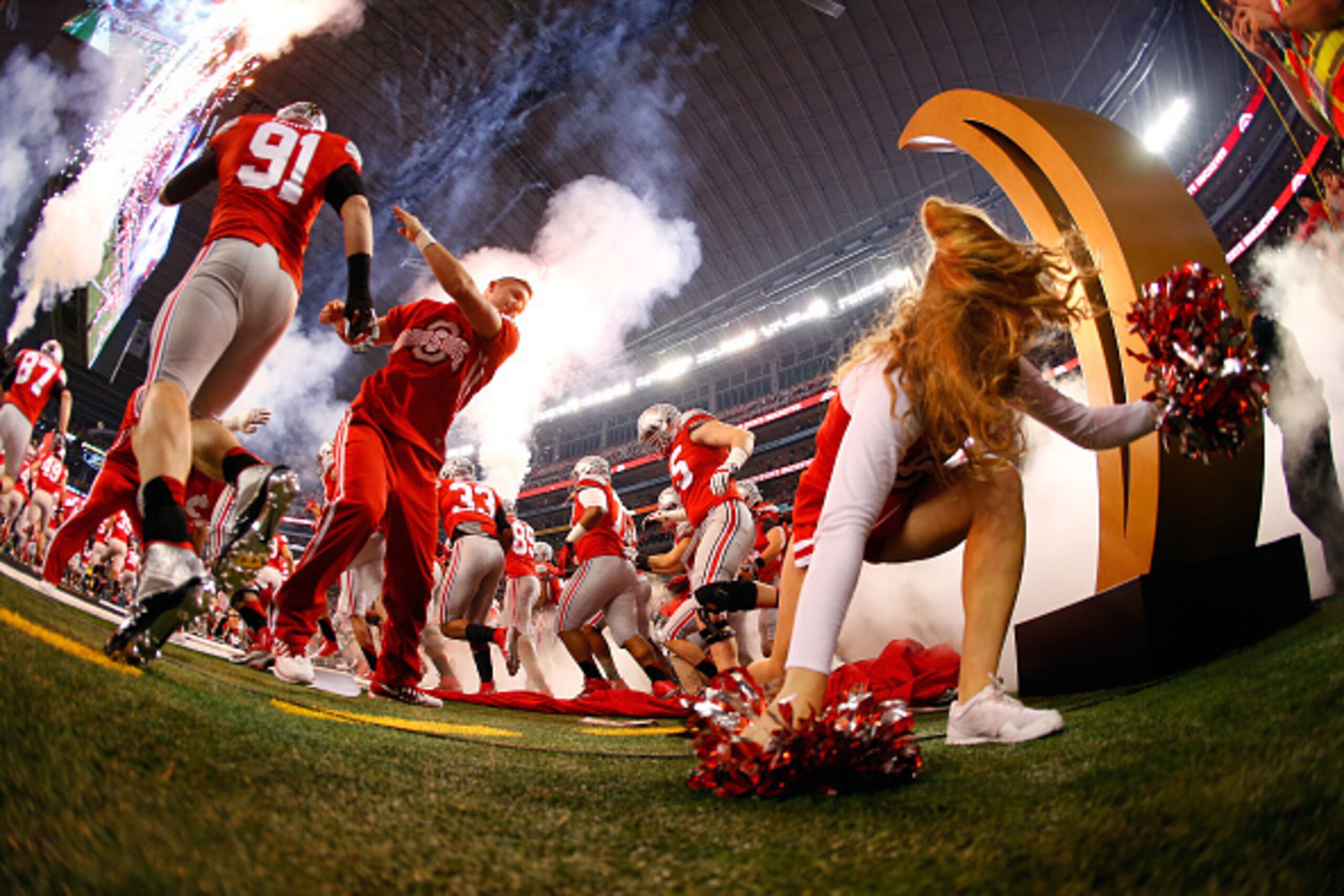 ARLINGTON, TX - JANUARY 12:  A Ohio State Buckeyes cheerleader falls as the Buckeyes run out to the field before the College Football Playoff National Championship Game at AT&T Stadium on January 12, 2015 in Arlington, Texas.  (Photo by Tom Pennington/Get