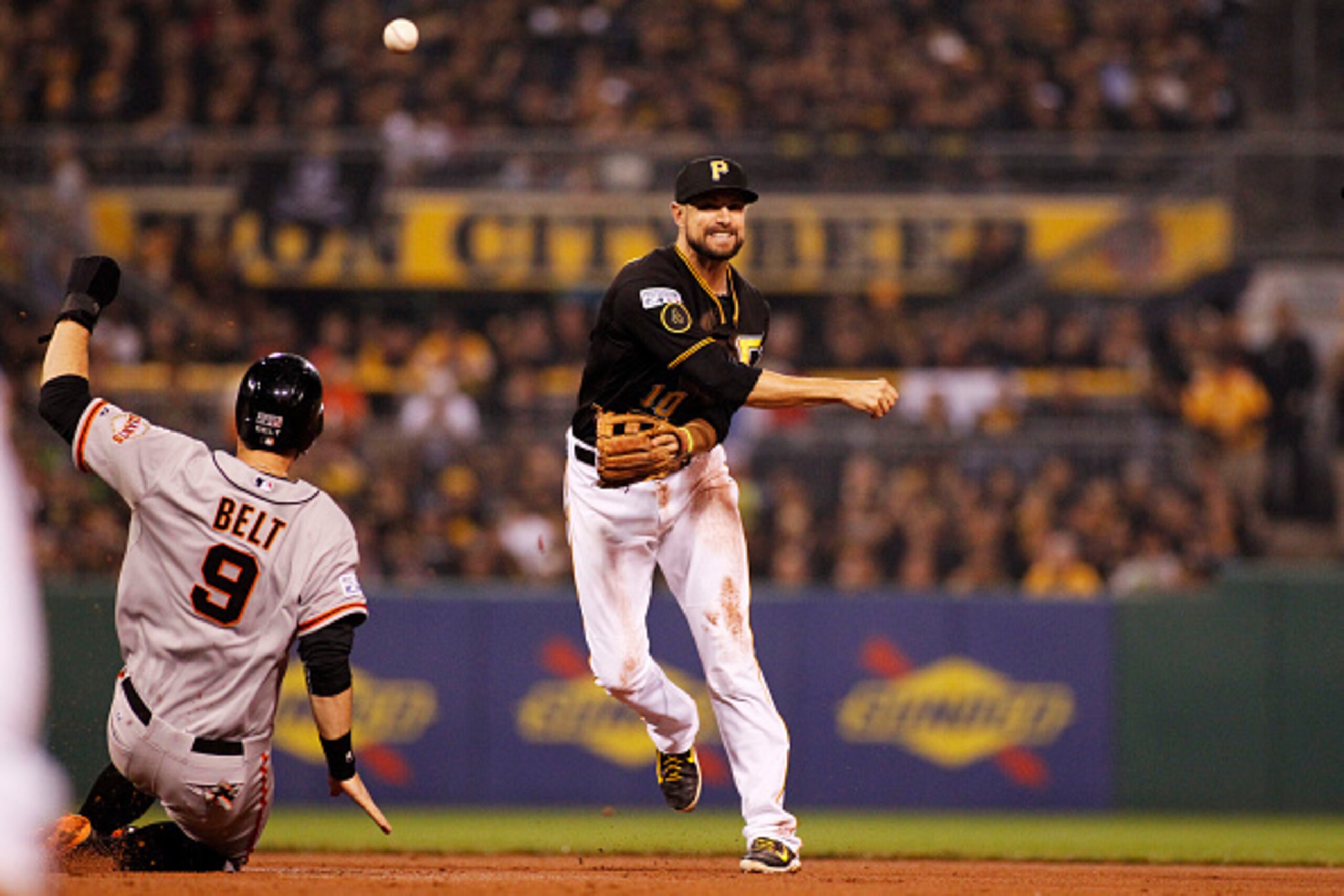 PITTSBURGH, PA - OCTOBER 01:  Jordy Mercer #10 of the Pittsburgh Pirates turns a double play to end the top of the seventh inning as Brandon Belt #9 of the San Francisco Giants slides to second base during the National League Wild Card game at PNC Park on