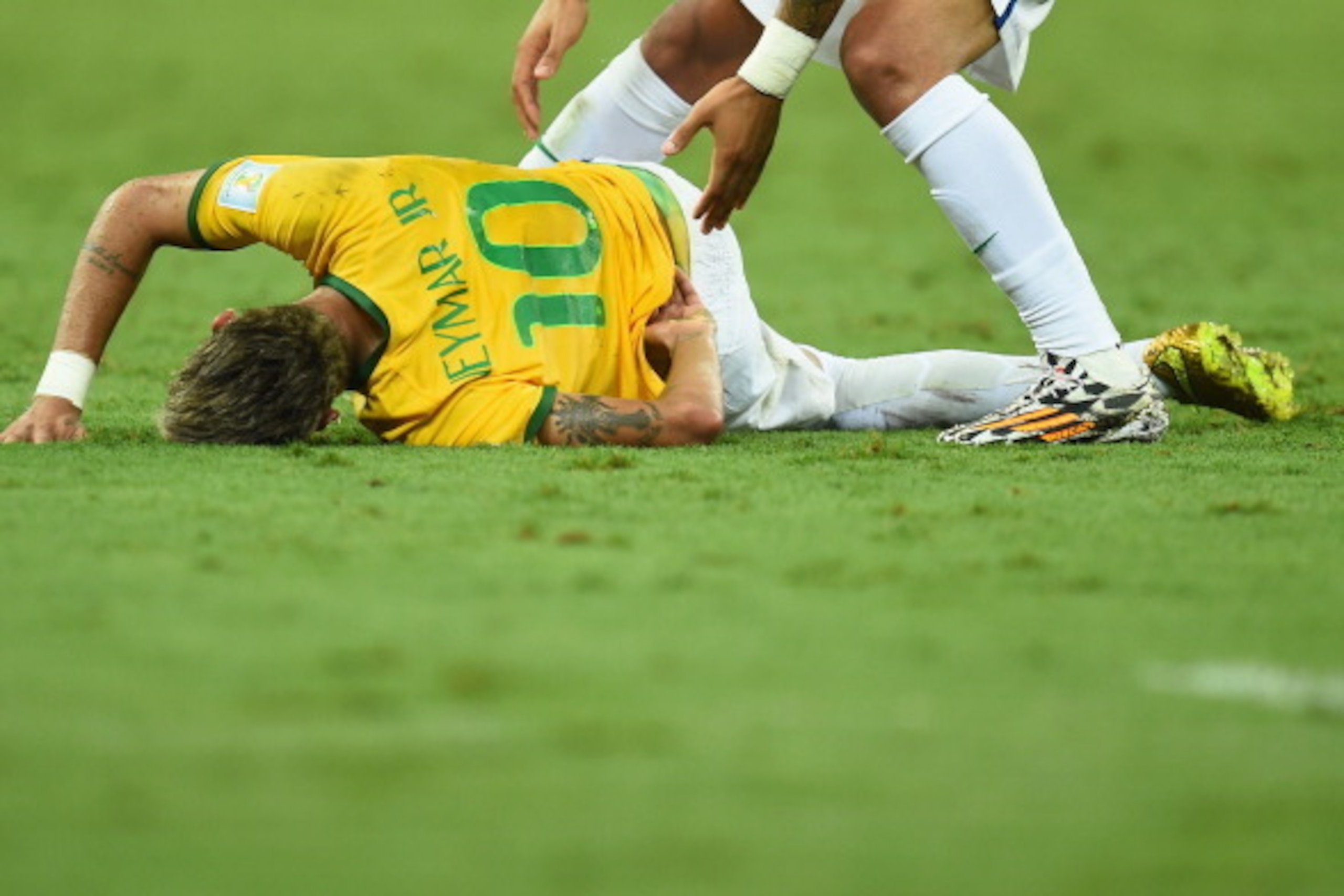 FORTALEZA, BRAZIL - JULY 04: Neymar of Brazil lies on the field after a challenge as teammate Marcelo reacts during the 2014 FIFA World Cup Brazil Quarter Final match between Brazil and Colombia at Castelao on July 4, 2014 in Fortaleza, Brazil. (Photo b FORTALEZA, BRAZIL - JULY 04: Neymar of Brazil lies on the field after a challenge as teammate Marcelo reacts during the 2014 FIFA World Cup Brazil Quarter Final match between Brazil and Colombia at Castelao on July 4, 2014 in Fortaleza, Brazil. (Photo b