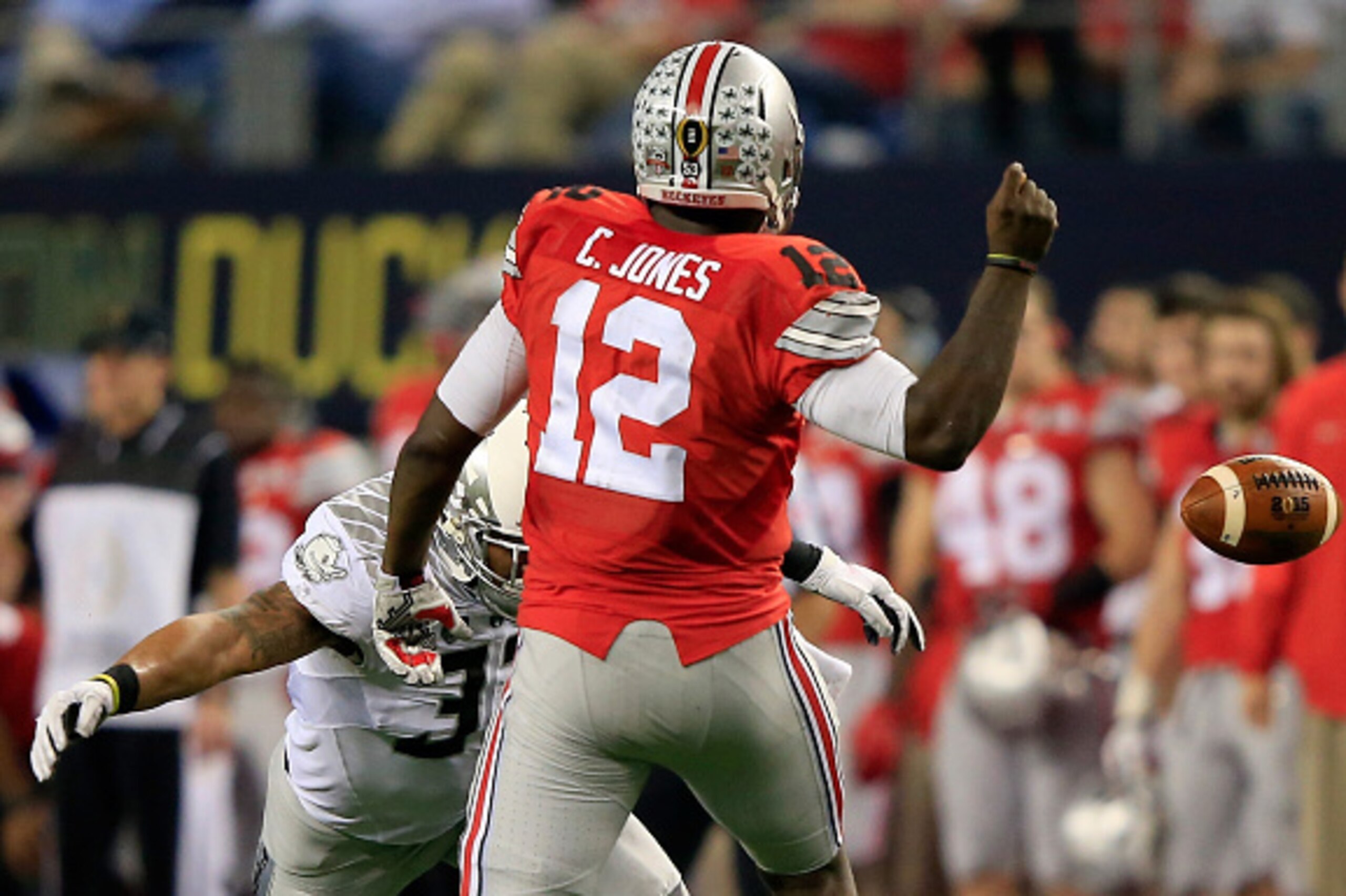 ARLINGTON, TX - JANUARY 12:  Quarterback Cardale Jones #12 of the Ohio State Buckeyes looses the ball in the third quarter against linebacker Tyson Coleman #33 of the Oregon Ducks during the College Football Playoff National Championship Game at AT&T Stad