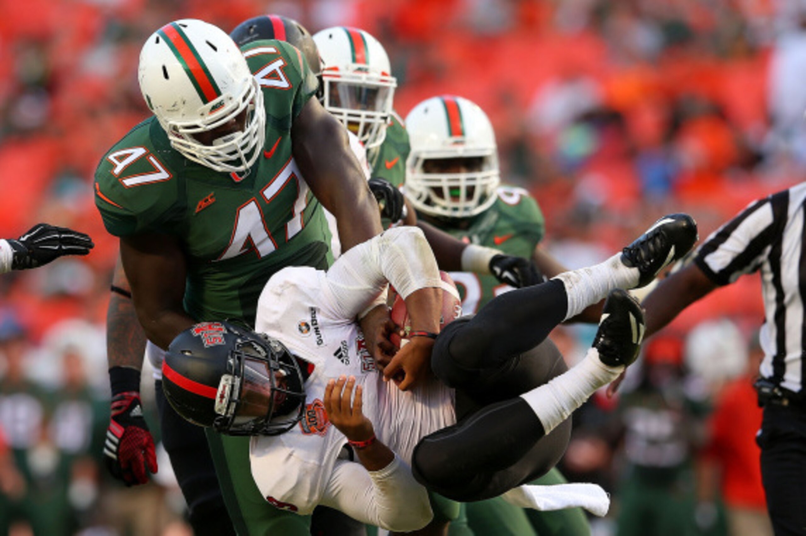 MIAMI, FL - SEPTEMBER 13:  Fredi Knighten #9 of the Arkansas State Red Wolves is sacked by Ufomba Kamalu #47 of the Miami Hurricanes during a game  at Sunlife Stadium on September 13, 2014 in Miami, Florida.  (Photo by Mike Ehrmann/Getty Images)
