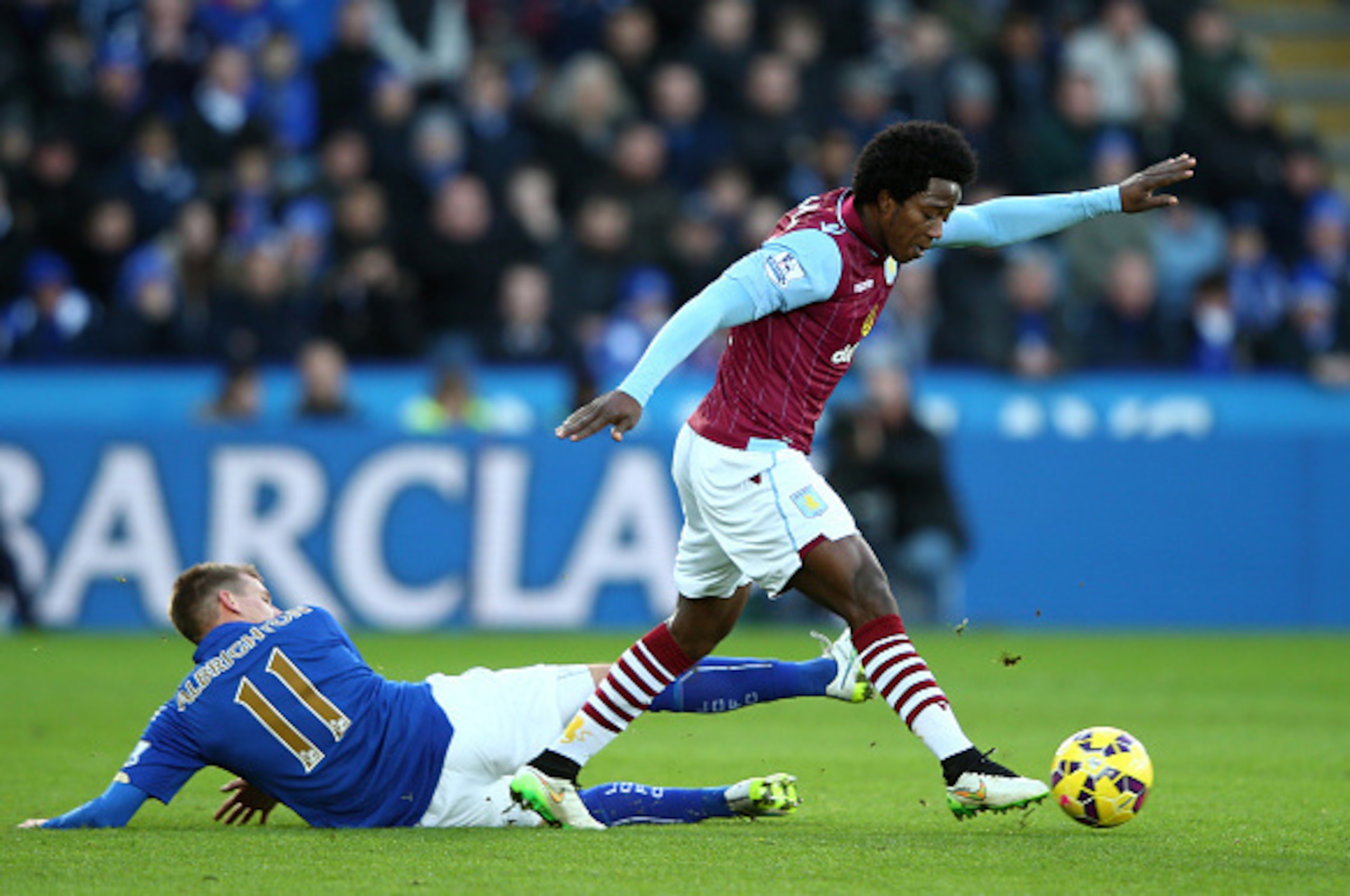 LEICESTER, ENGLAND - JANUARY 10:  Carlos Sanchez of Aston Villa skiups past the challenge from Marc Albrighton of Leicester City during the Barclays Premier League match between Leicester City and Aston Villa at The King Power Stadium on January 10, 2015 