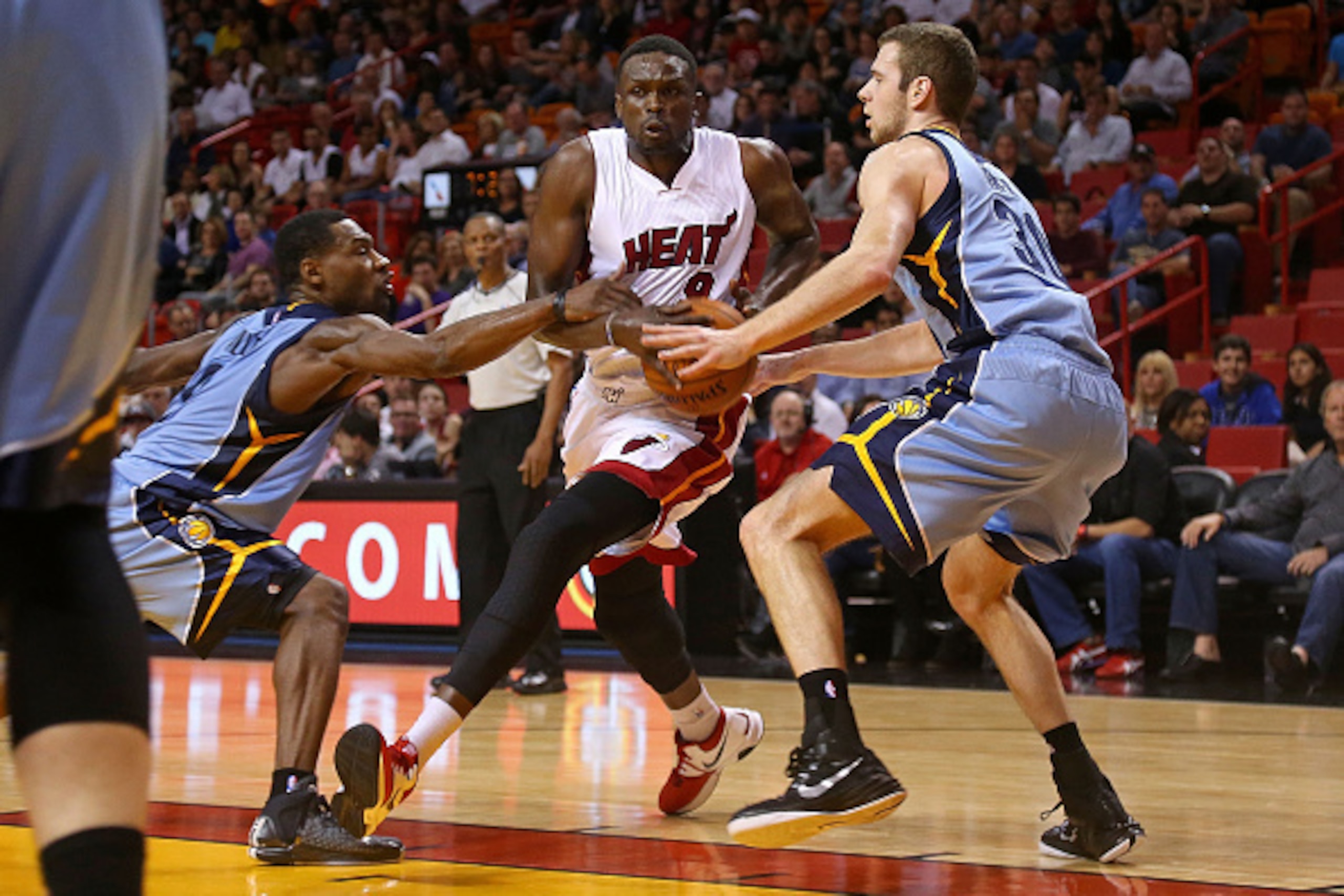 MIAMI, FL - DECEMBER 27: Luol Deng #9 of the Miami Heat is guarded by Jon Leuer #30 and Tony Allen #9 of the Memphis Grizzlies during a game  at American Airlines Arena on December 27, 2014 in Miami, Florida. NOTE TO USER: User expressly acknowledges and 