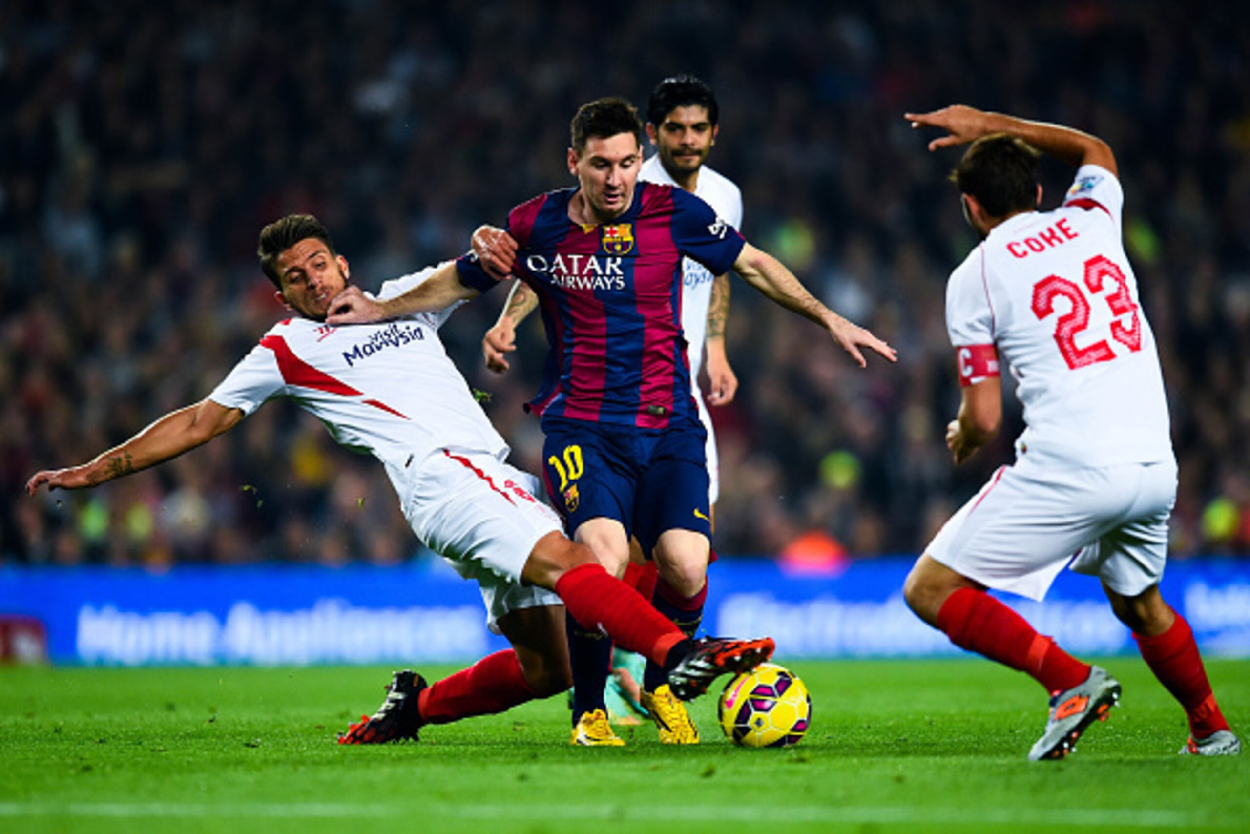 BARCELONA, SPAIN - NOVEMBER 22:  Lionel Messi of FC Barcelona duels for the ball with Daniel Filipe Martins Carrico (L) and Jorge Andujar Moreno 'Coke' of Sevilla FC of Sevilla FCat Camp Nou on November 22, 2014 in Barcelona, Spain.  (Photo by David Ramos