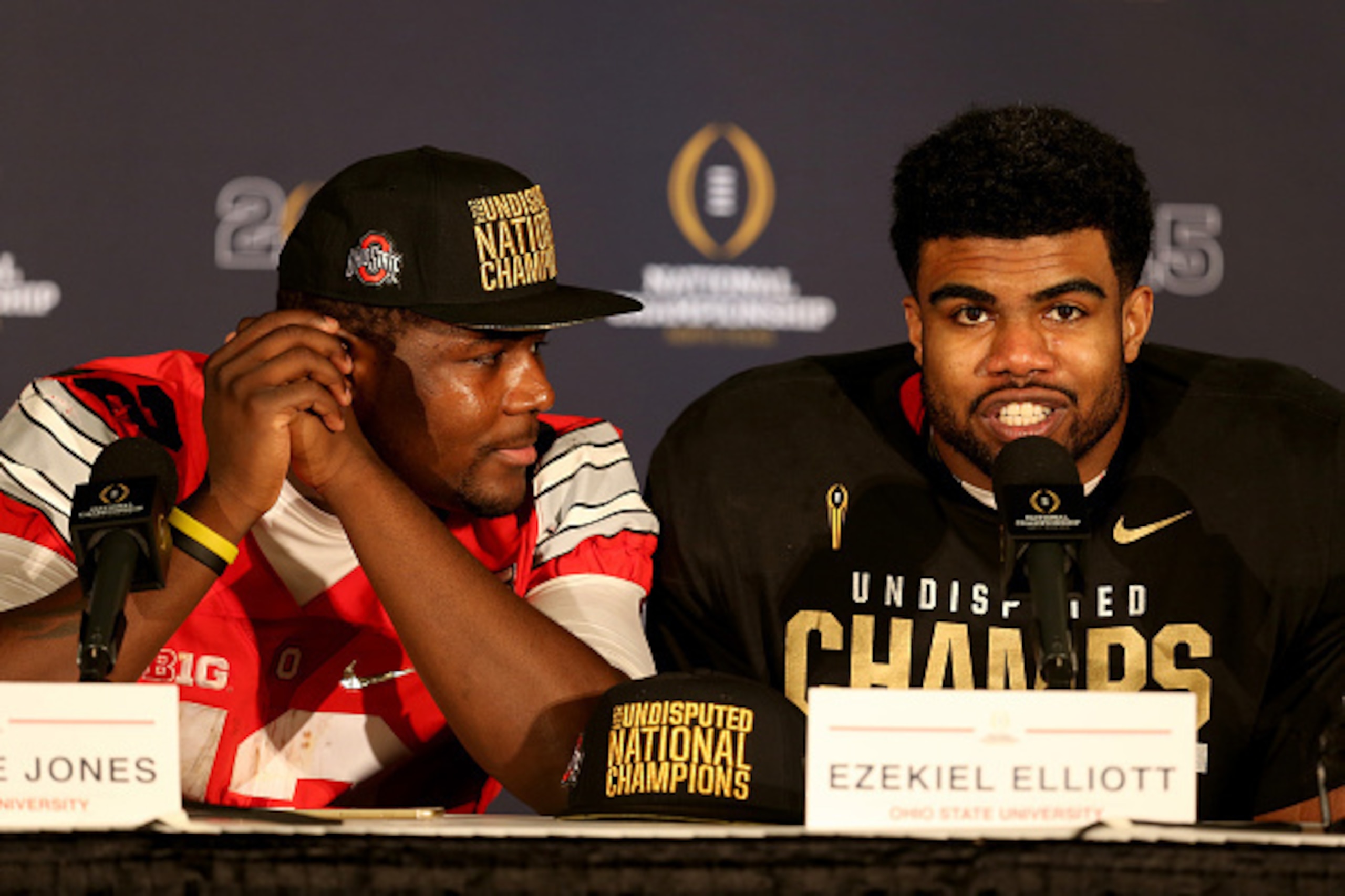 ARLINGTON, TX - JANUARY 12:  (L-R) Quarterback Cardale Jones #12 and running back Ezekiel Elliott #15 of the Ohio State Buckeyes talk to the media after defeating the Oregon Ducks in the College Football Playoff National Championship Game at AT&T Stadium 