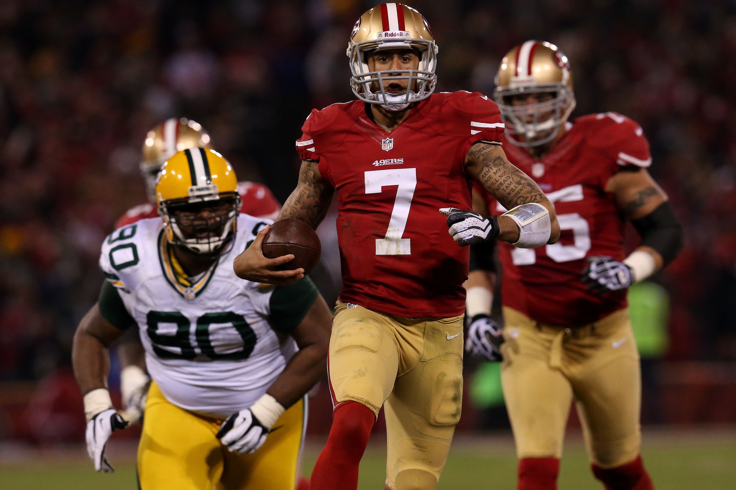 SAN FRANCISCO, CA - JANUARY 12:  Quarterback Colin Kaepernick #7 of the San Francisco 49ers runs the ball against nose tackle B.J. Raji #90 of the Green Bay Packers during the NFC Divisional Playoff Game at Candlestick Park on January 12, 2013 in San Fran