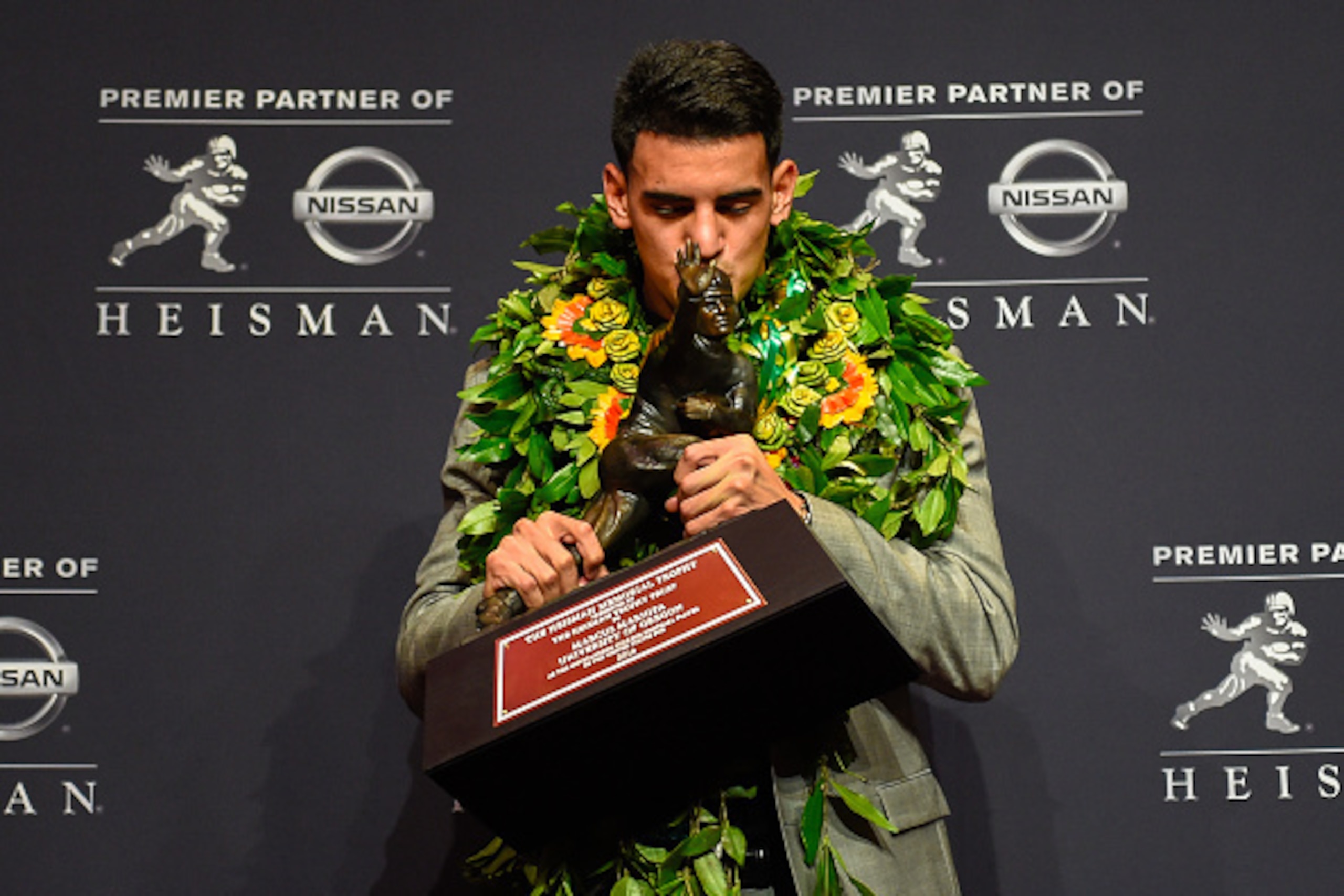 NEW YORK, NY - DECEMBER 13:  Oregon Ducks quarterback Marcus Mariota poses with the Heisman Trophy during a press conference after the 2014 Heisman Trophy presentation at the New York Marriott Marquis on December 13, 2014 in New York City.  (Photo by Alex