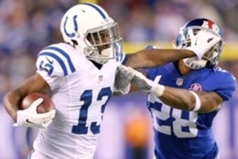 Nov 3, 2014; East Rutherford, NJ, USA; Indianapolis Colts wide receiver T.Y. Hilton (13) stiff-arms New York Giants corner back Jayron Hosley (28) after a catch during the second quarter at MetLife Stadium. Mandatory Credit: Brad Penner-USA TODAY Sports