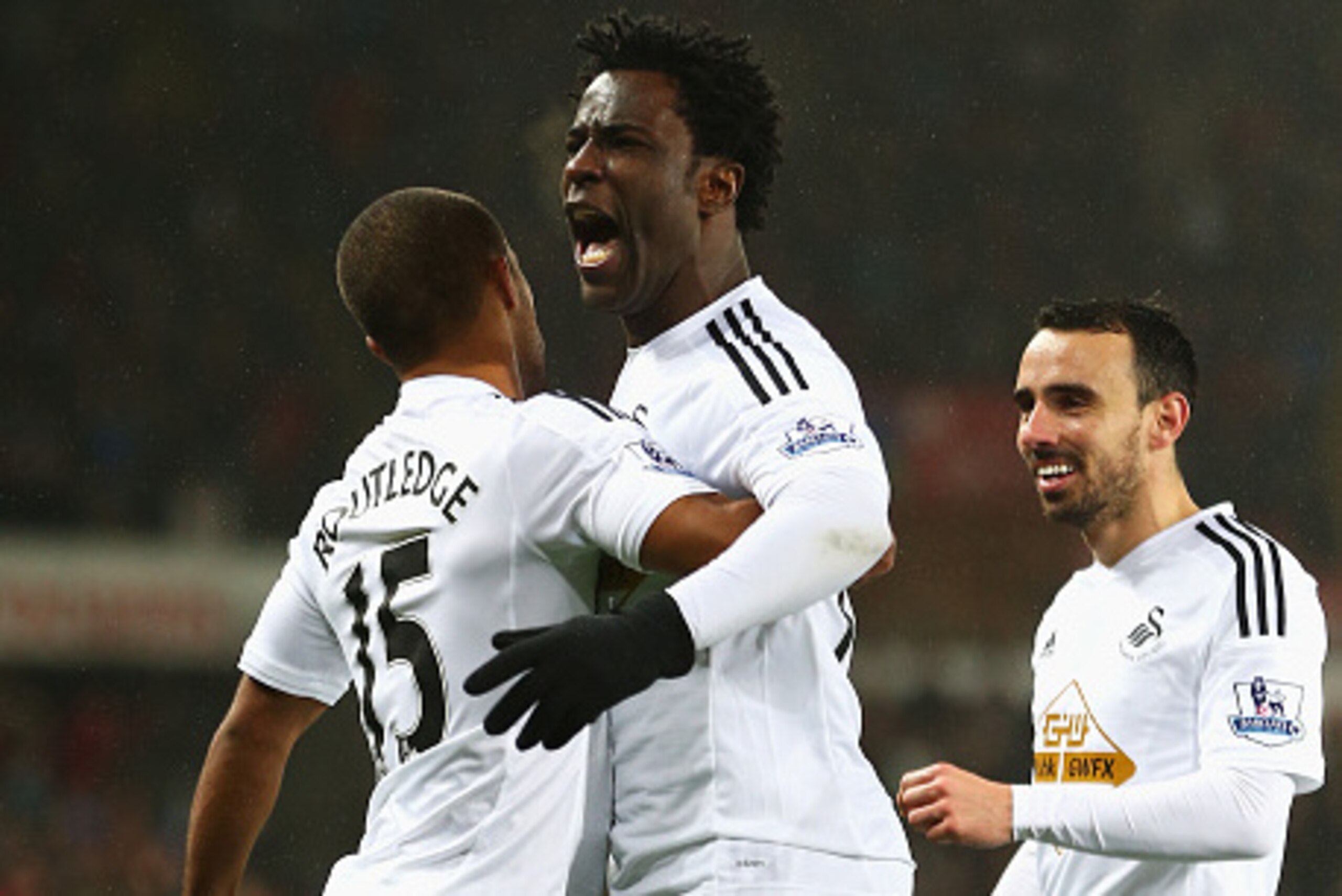 SWANSEA, WALES - DECEMBER 14:  Wilfried Bony (C) of Swansea City celebrates his goal with Wayne Routledge (L) and Leon Britton during the Barclays Premier League match between Swansea City and Tottenham Hotspur at Liberty Stadium on December 14, 2014 in S