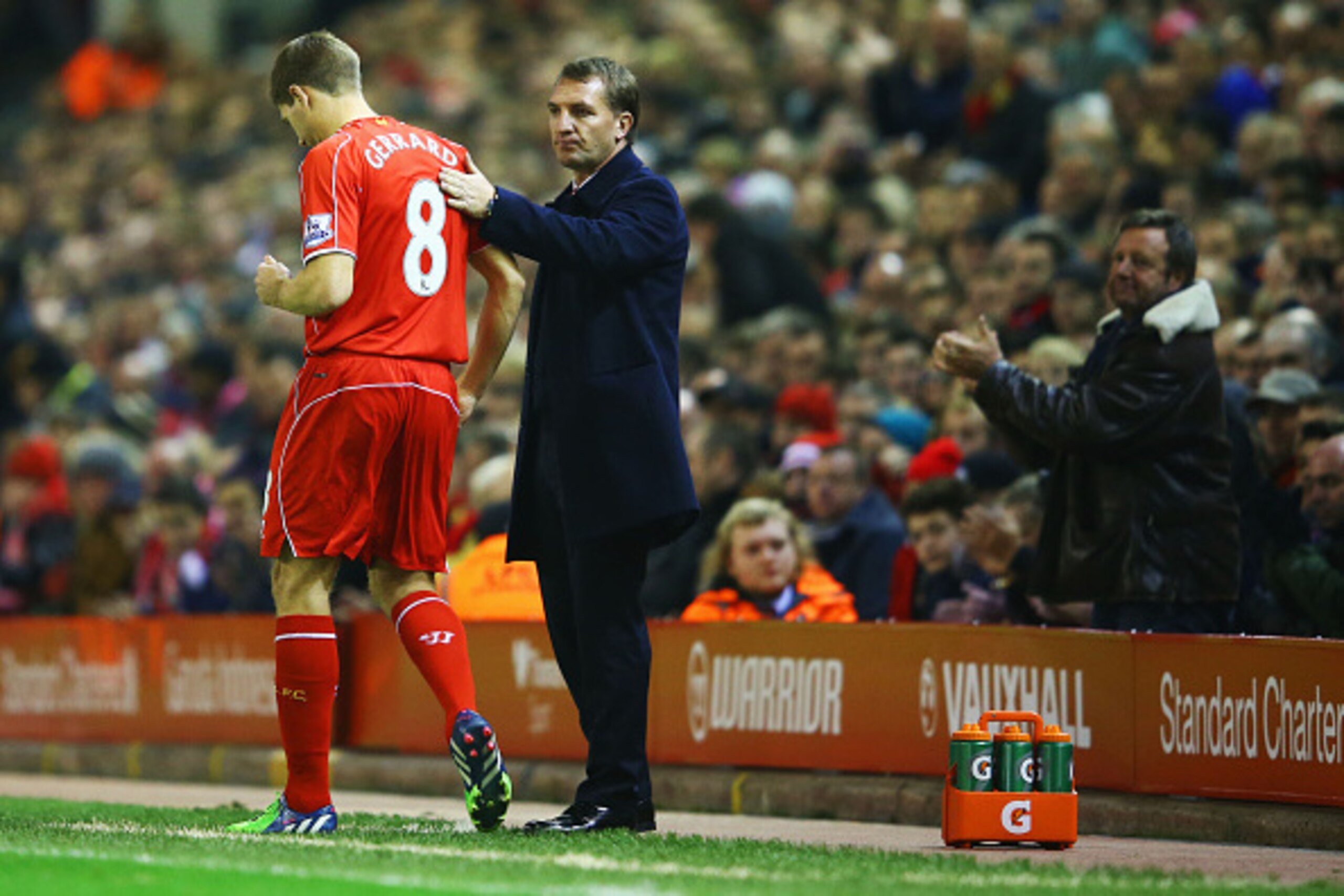 LIVERPOOL, ENGLAND - NOVEMBER 29:  A fan applauds as Steven Gerrard of Liverpool prepares to come onto the pitch as a substitute alongside Brendan Rodgers manager of Liverpool during the Barclays Premier League match between Liverpool and Stoke City at An
