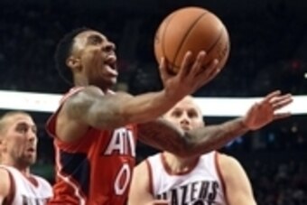 Jan 3, 2014; Portland, OR, USA; Atlanta Hawks guard Jeff Teague (0) drives to the basket on Portland Trail Blazers guard Steve Blake (25) and center Chris Kaman (35) during the fourth quarter of the game at the Moda Center at the Rose Quarter. The Hawks w