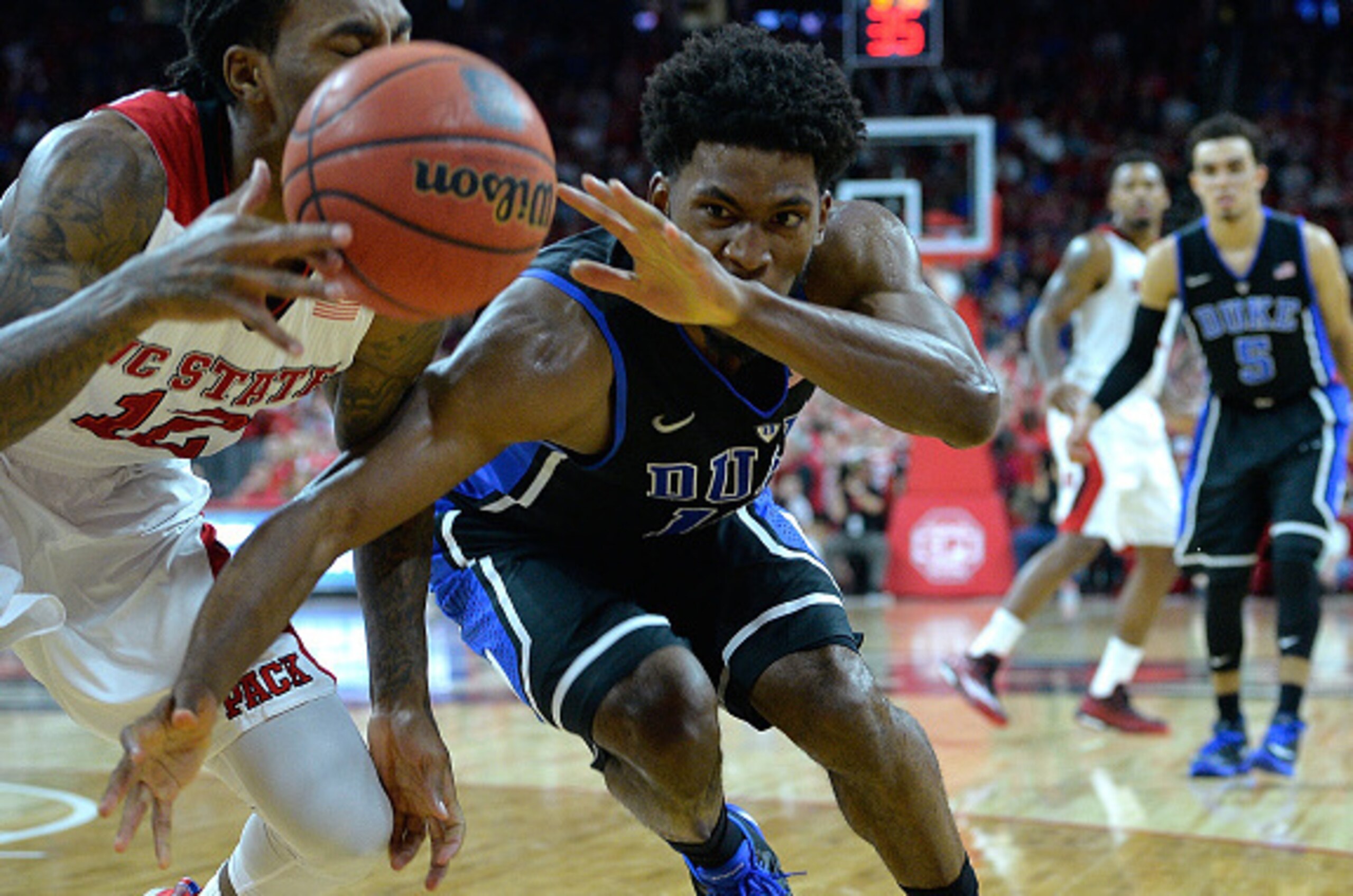 RALEIGH, NC - JANUARY 11:  Anthony Barber #12 of the North Carolina State Wolfpack battles Justise Winslow #12 of the Duke Blue Devils for loose ball along the baseline during their game at PNC Arena on January 11, 2015 in Raleigh, North Carolina. North C