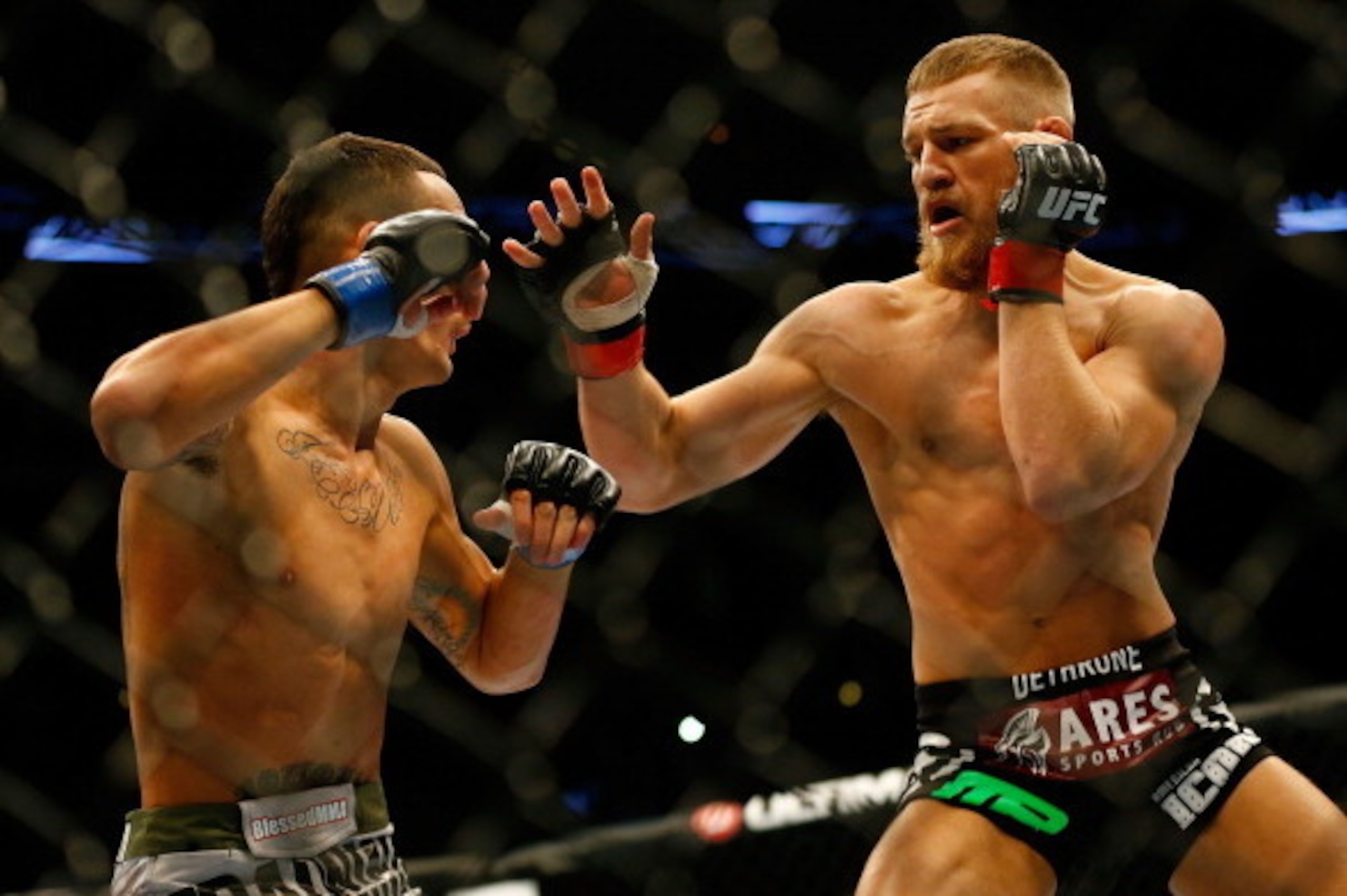 BOSTON, MA - AUGUST 17: Conor McGregor punches Max Holloway in their featherweight bout at TD Garden on August 17, 2013 in Boston, Massachusetts. (Photo by Jared Wickerham/Getty Images)