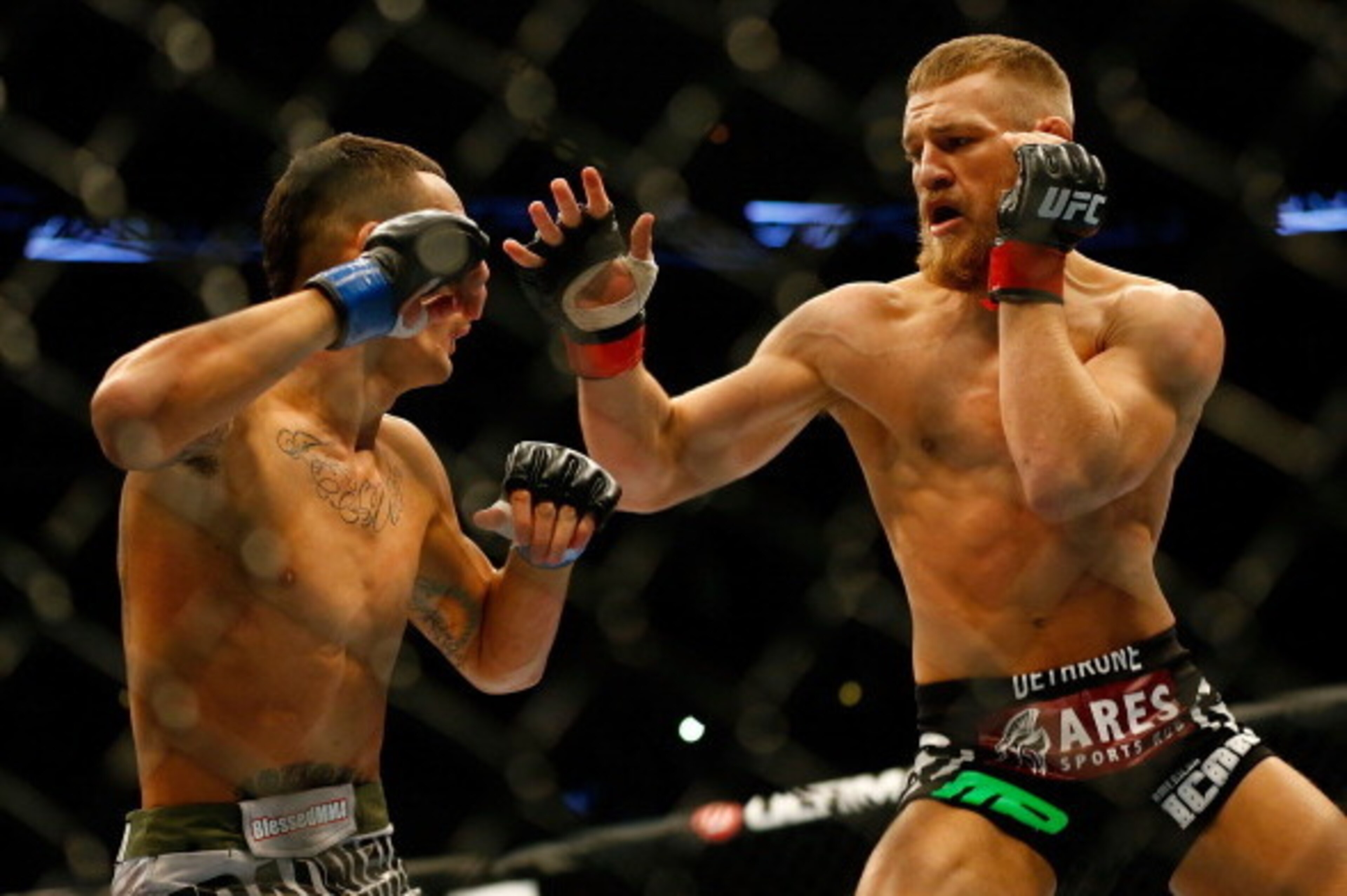 BOSTON, MA - AUGUST 17: Conor McGregor punches Max Holloway in their featherweight bout at TD Garden on August 17, 2013 in Boston, Massachusetts. (Photo by Jared Wickerham/Getty Images) BOSTON, MA - AUGUST 17: Conor McGregor punches Max Holloway in their featherweight bout at TD Garden on August 17, 2013 in Boston, Massachusetts. (Photo by Jared Wickerham/Getty Images)