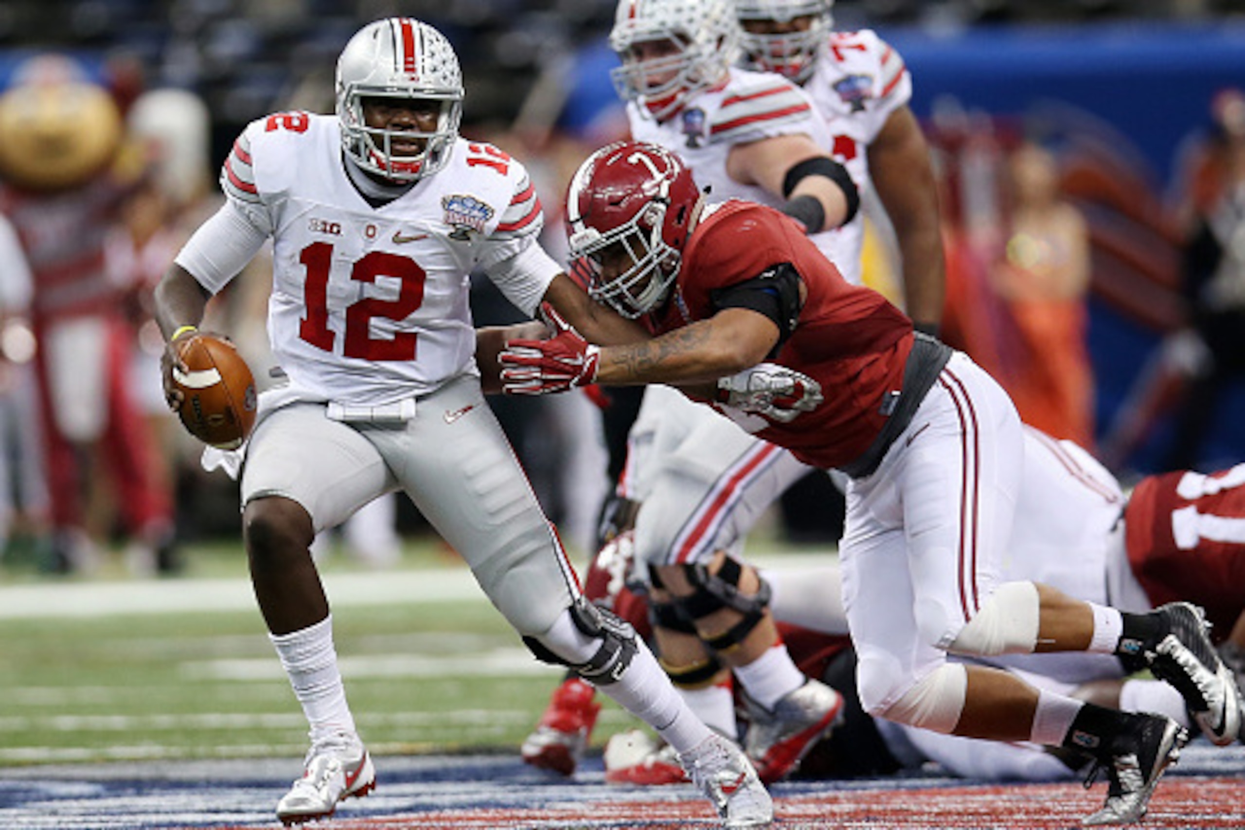 NEW ORLEANS, LA - JANUARY 01:  Cardale Jones #12 of the Ohio State Buckeyes avoids a tackle by Ryan Anderson #7 of the Alabama Crimson Tide during the All State Sugar Bowl at the Mercedes-Benz Superdome on January 1, 2015 in New Orleans, Louisiana.  (Phot