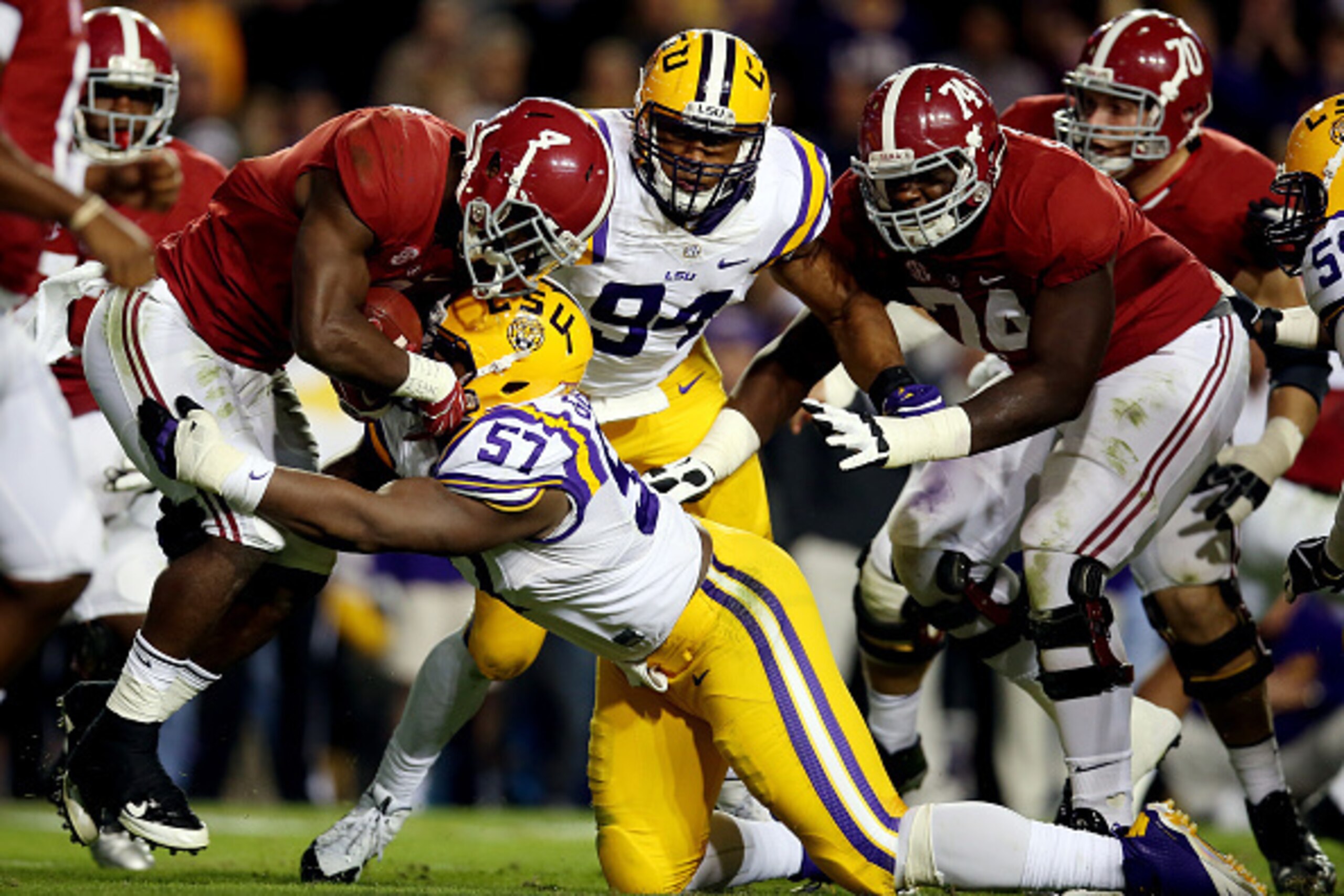 BATON ROUGE, LA - NOVEMBER 08: T.J. Yeldon #4 of the Alabama Crimson Tide is tackled by Davon Godchaux #57 of the LSU Tigers  during a game at Tiger Stadium on November 8, 2014 in Baton Rouge, Louisiana.  (Photo by Chris Graythen/Getty Images)