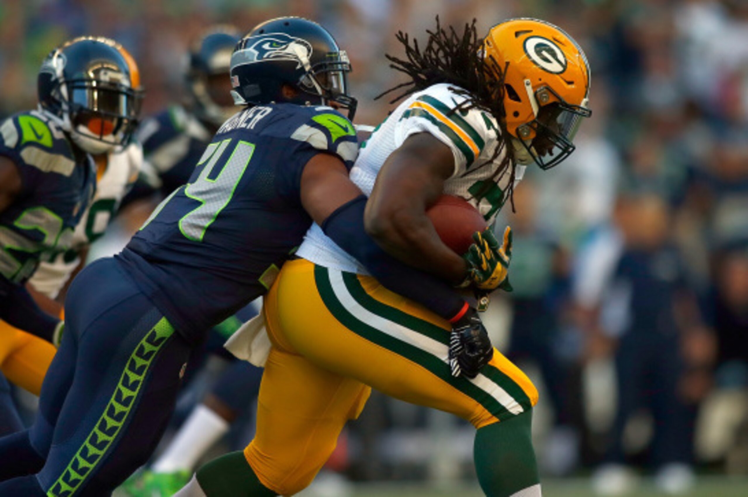 SEATTLE, WA - SEPTEMBER 04:  Running back Eddie Lacy #27  of the Green Bay Packers is brought down by linebacker Bobby Wagner #54 of the Seattle Seahawks during the first quarter of the game at CenturyLink Field on September 4, 2014 in Seattle, Washington