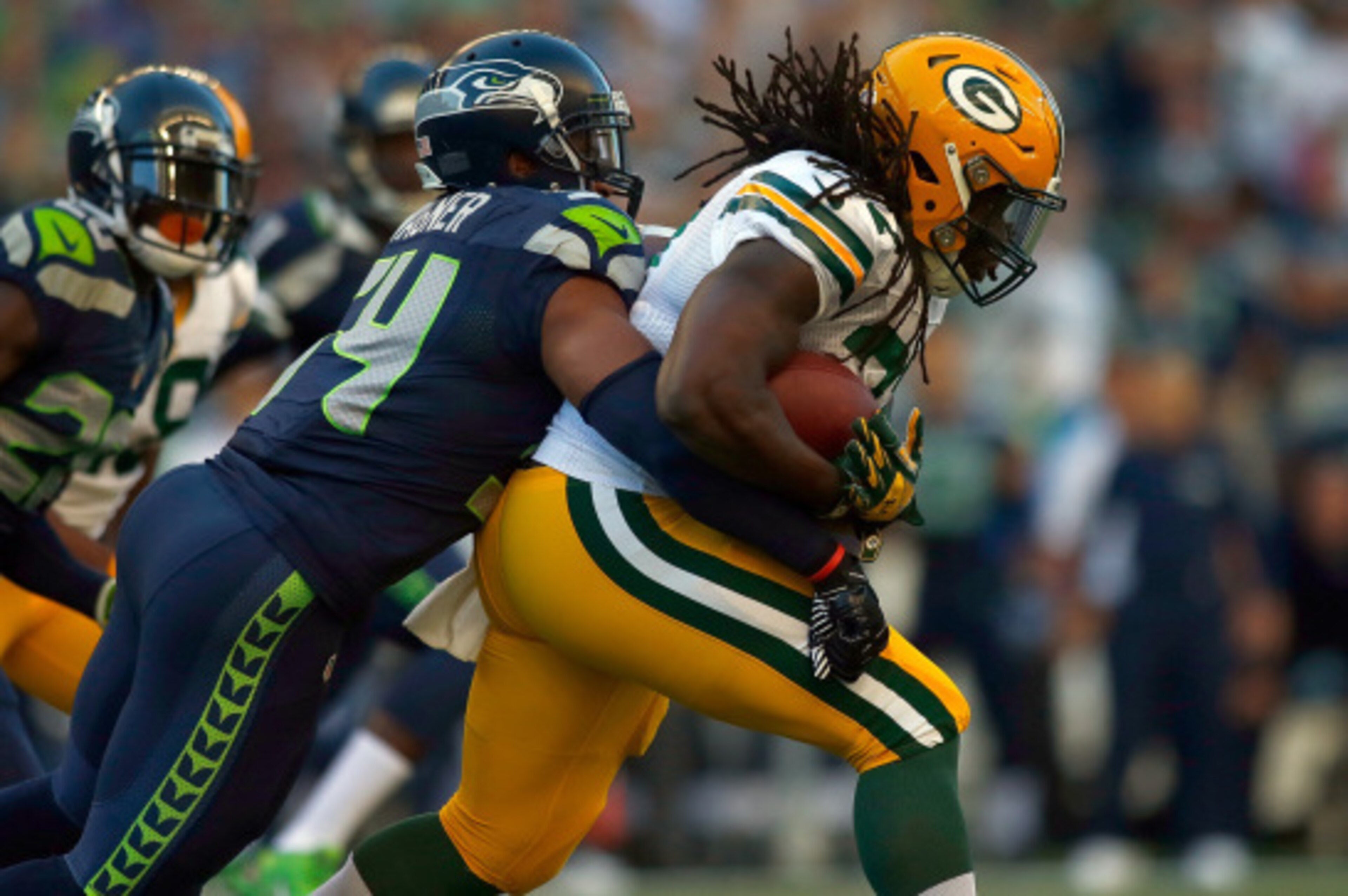 SEATTLE, WA - SEPTEMBER 04:  Running back Eddie Lacy #27  of the Green Bay Packers is brought down by linebacker Bobby Wagner #54 of the Seattle Seahawks during the first quarter of the game at CenturyLink Field on September 4, 2014 in Seattle, Washington