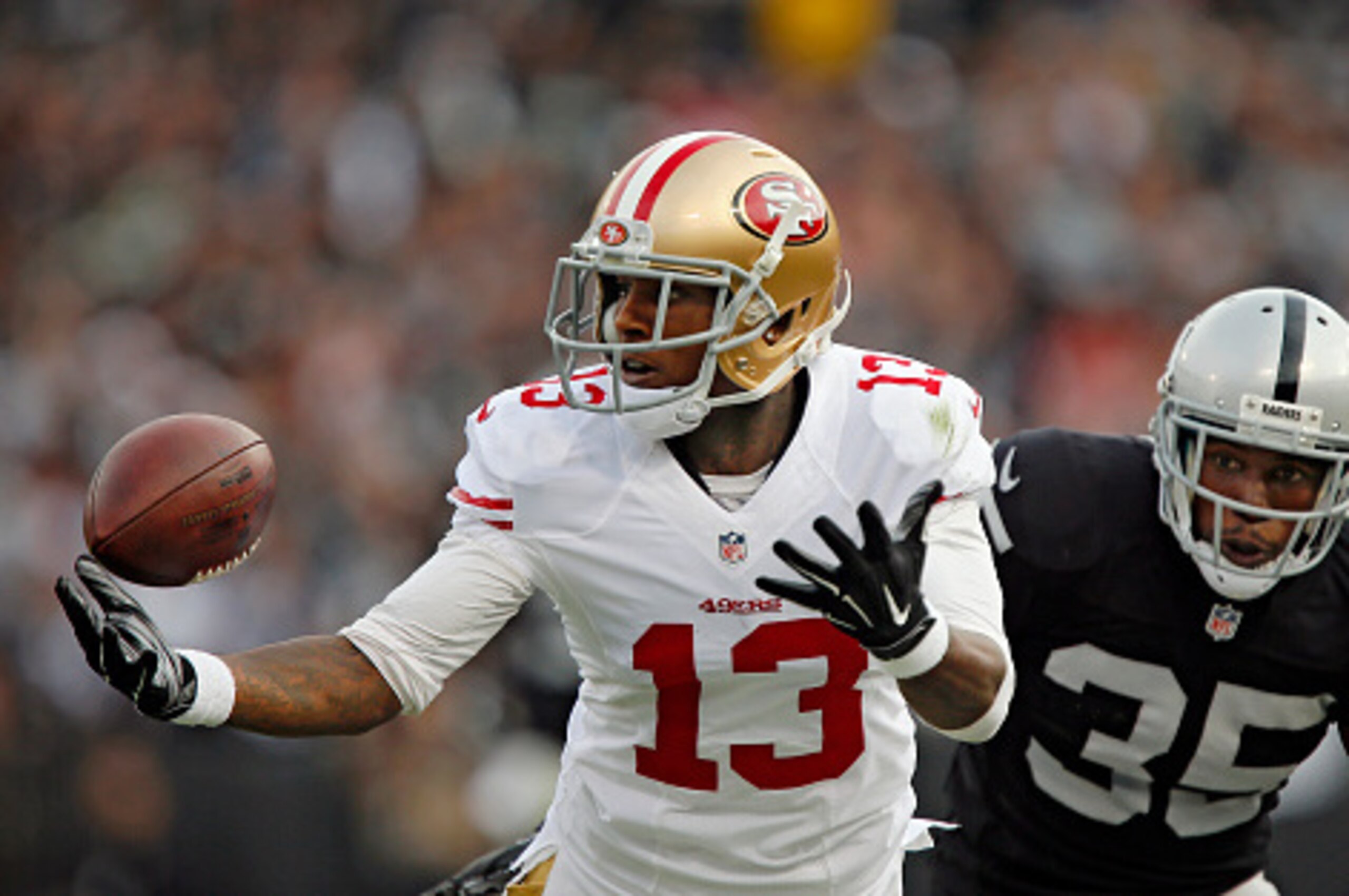 OAKLAND, CA - DECEMBER 7:  Wide receiver Stevie Johnson #13 of the San Francisco 49ers tries unsuccessfully to pull down a pass against cornerback Chimdi Chekwa #35 of the Oakland Raiders in the second quarter on December 7, 2014 at O.co Coliseum in Oakla