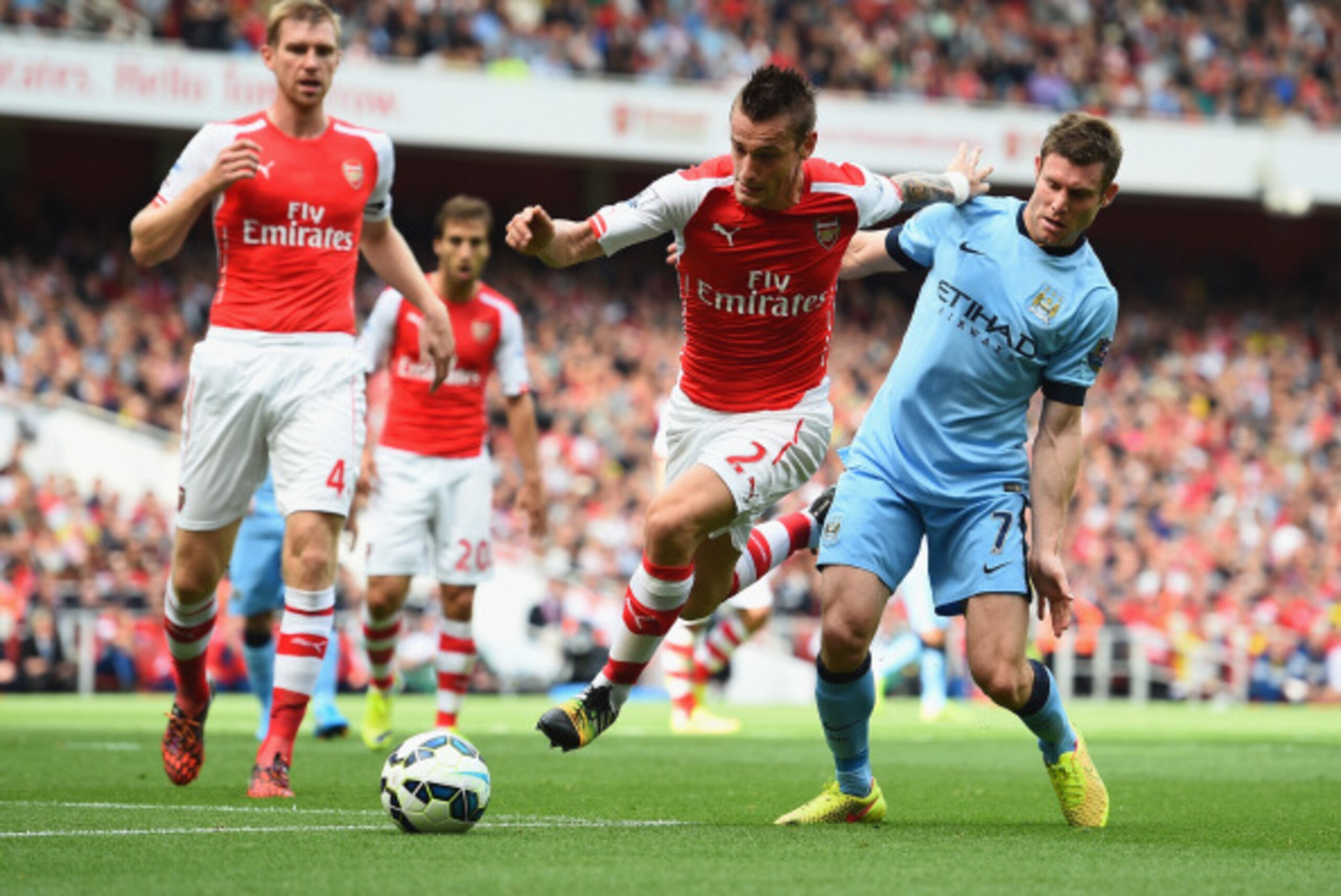 LONDON, ENGLAND - SEPTEMBER 13:  Mathieu Debuchy of Arsenal is challenged by James Milner of Manchester City during the Barclays Premier League match between Arsenal and Manchester City at Emirates Stadium on September 13, 2014 in London, England.  (Photo