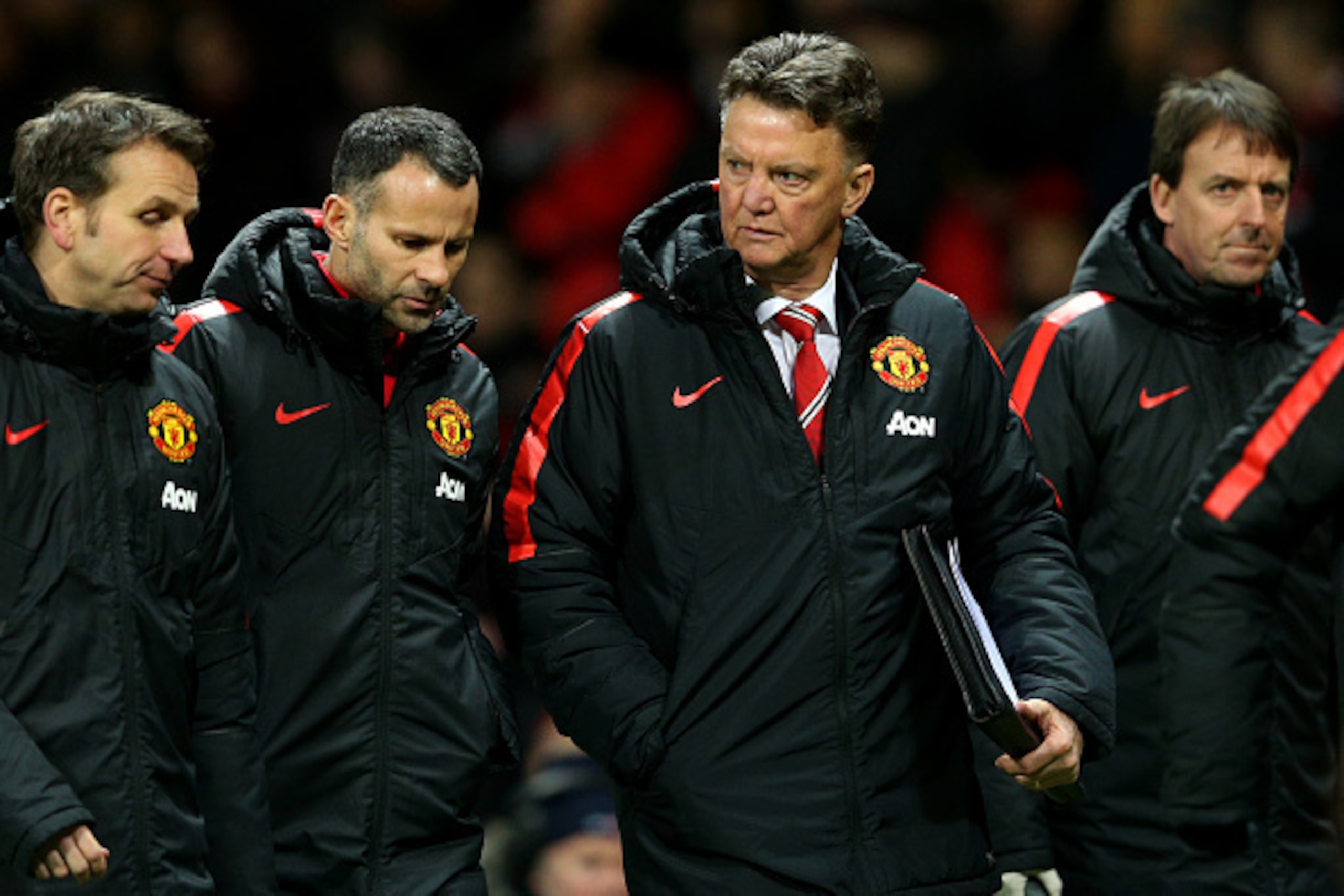 MANCHESTER, ENGLAND - JANUARY 11:  Louis van Gaal, manager of Manchester United, assistant manager Ryan Giggs and assistant coach Albert Stuivenberg (L) speak as they leave the pitch at half-time during the Barclays Premier League match between Manchester