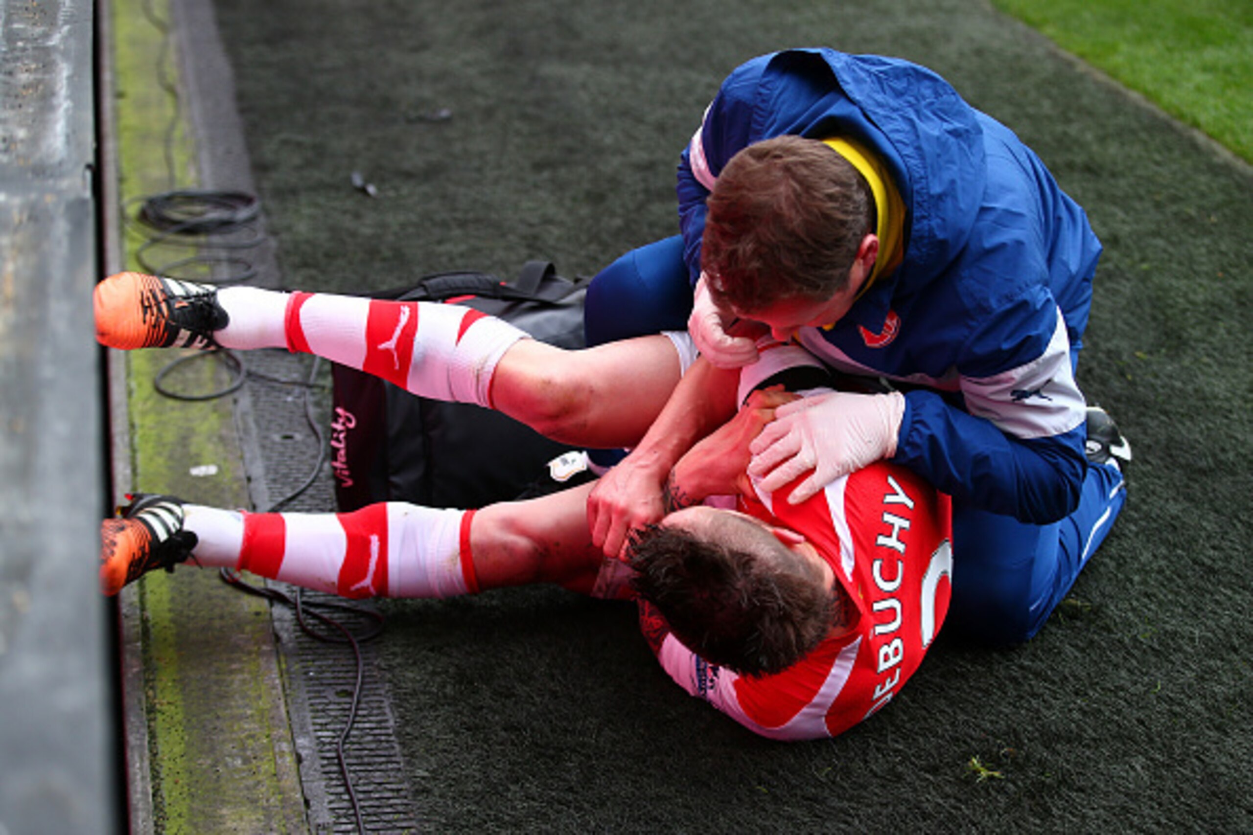 LONDON, ENGLAND - JANUARY 11:  Mathieu Debuchy of Arsenal receives treatment for an injury before being stretchered off during the Barclays Premier League match between Arsenal and Stoke City at Emirates Stadium on January 11, 2015 in London, England.  (P