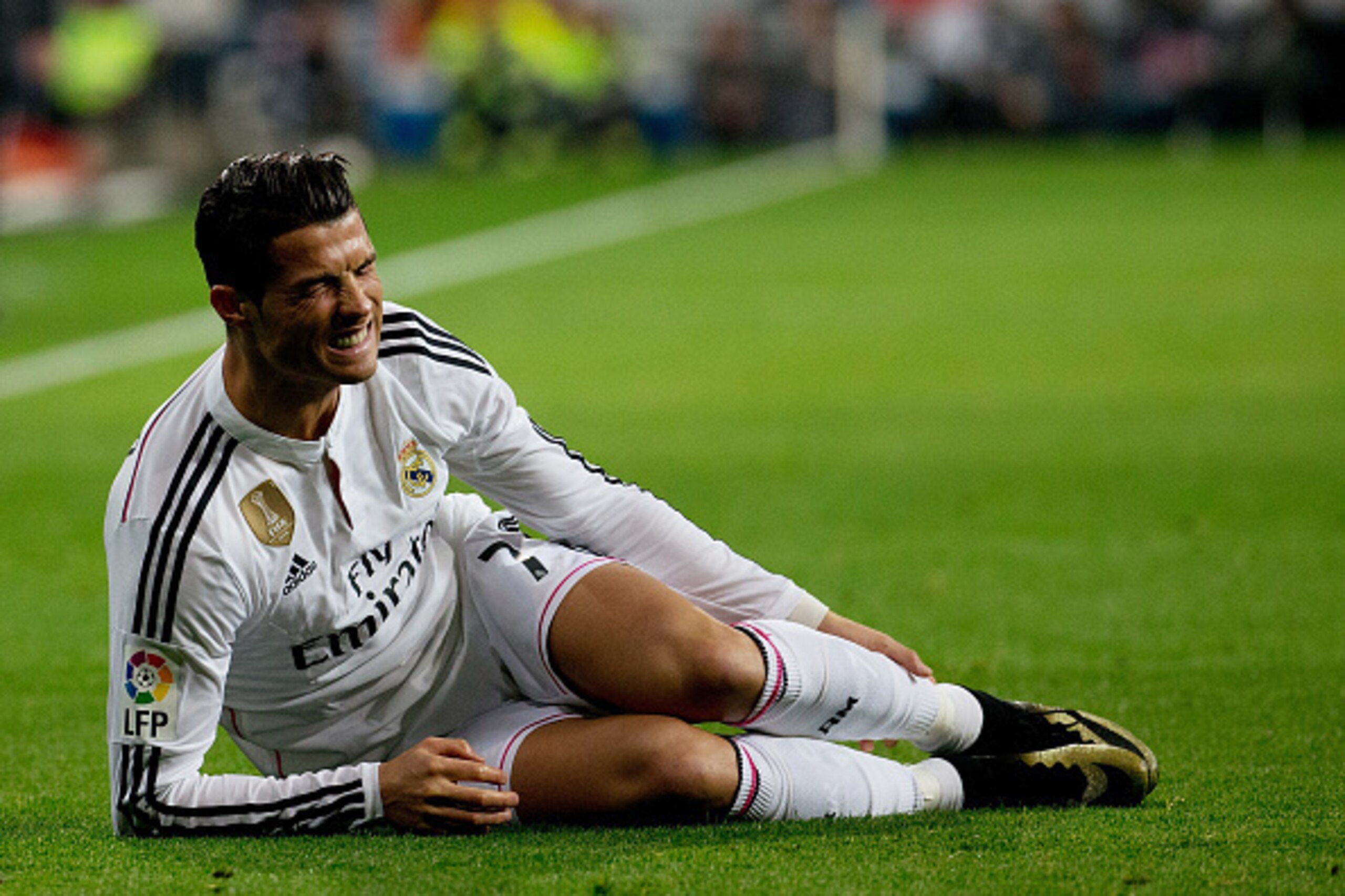 MADRID, SPAIN - JANUARY 15:  Cristiano Ronaldo of Real Madrid CF grimaces in pain lied on the ground during the Copa del Rey Round of 16  second leg match between Real Madrid CF and Club Atletico de Madrid at Estadio Santiago Bernabeu on January 15, 2015 