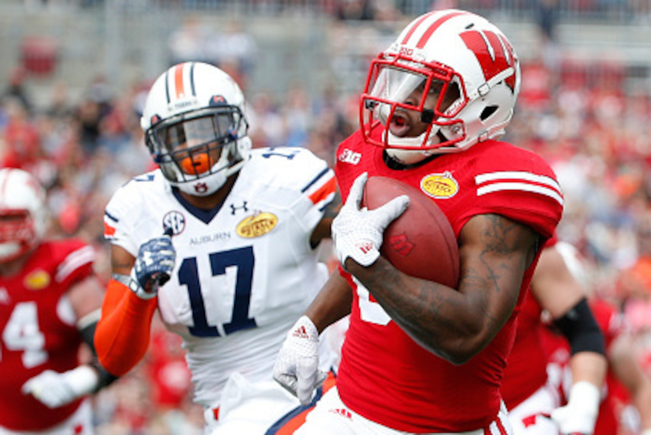 TAMPA, FL - JANUARY 1:   Running back Corey Clement #6 of the Wisconsin Badgers evades linebacker Kris Frost #17 of the Auburn Tigers during a carry for 43 yards to set up a touchdown on the next play in the first quarter of the Outback Bowl on January 1,