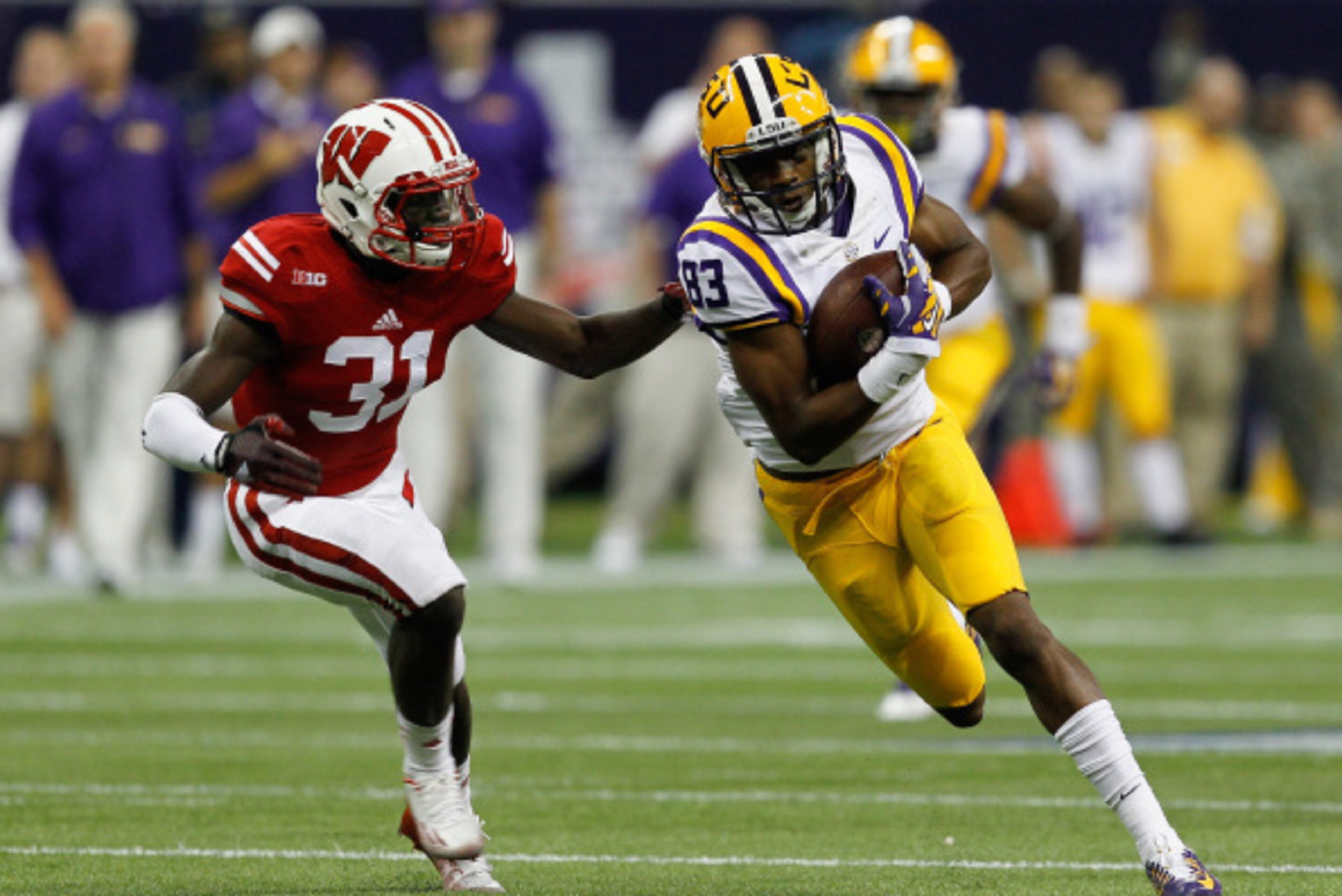 HOUSTON, TX - AUGUST 30:  Travin Dural #83 of the LSU Tigers runs with the ball after a reception as Lubern Figaro #31 of the Wisconsin Badgers attempts a tackle at NRG Stadium on August 30, 2014 in Houston, Texas.  (Photo by Bob Levey/Getty Images)