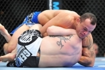 Feb 2, 2013; Las Vegas, NV, USA; Gleison Tibau (top) attempts a guillotine choke on Evan Dunham (bottom) during UFC 156 at the Mandalay Bay Events Center. Mandatory Credit: Gary A. Vasquez-USA TODAY Sports