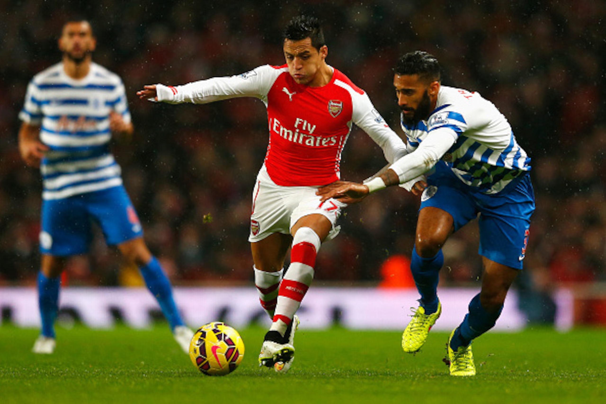 LONDON, ENGLAND - DECEMBER 26: Alexis Sanchez of Arsenal is closed down by Armand Traore of QPR during the Barclays Premier League match between Arsenal and Queens Park Rangers at Emirates Stadium on December 26, 2014 in London, England.  (Photo by Julian