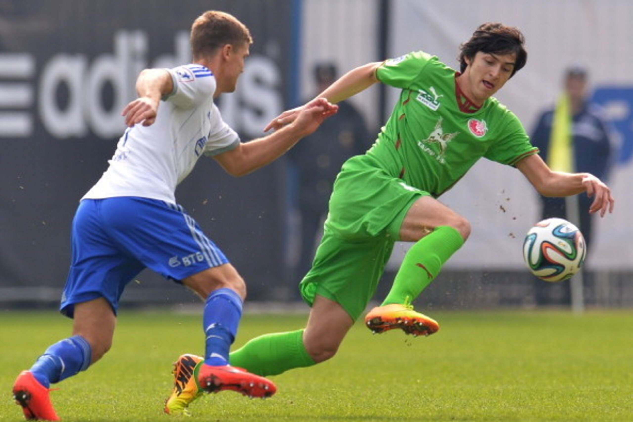 KHIMKI, RUSSIA - MARCH 23: Igor Denisov (L) of FC Dinamo Moscow challenged by Sardar Azmoun of FC Rubin Kazan during the Russian Premier League match between FC Dinamo Moscow and FC Rubin Kazan at the Arena Khimki Stadium on March 23, 2014 in Khimki, Russ
