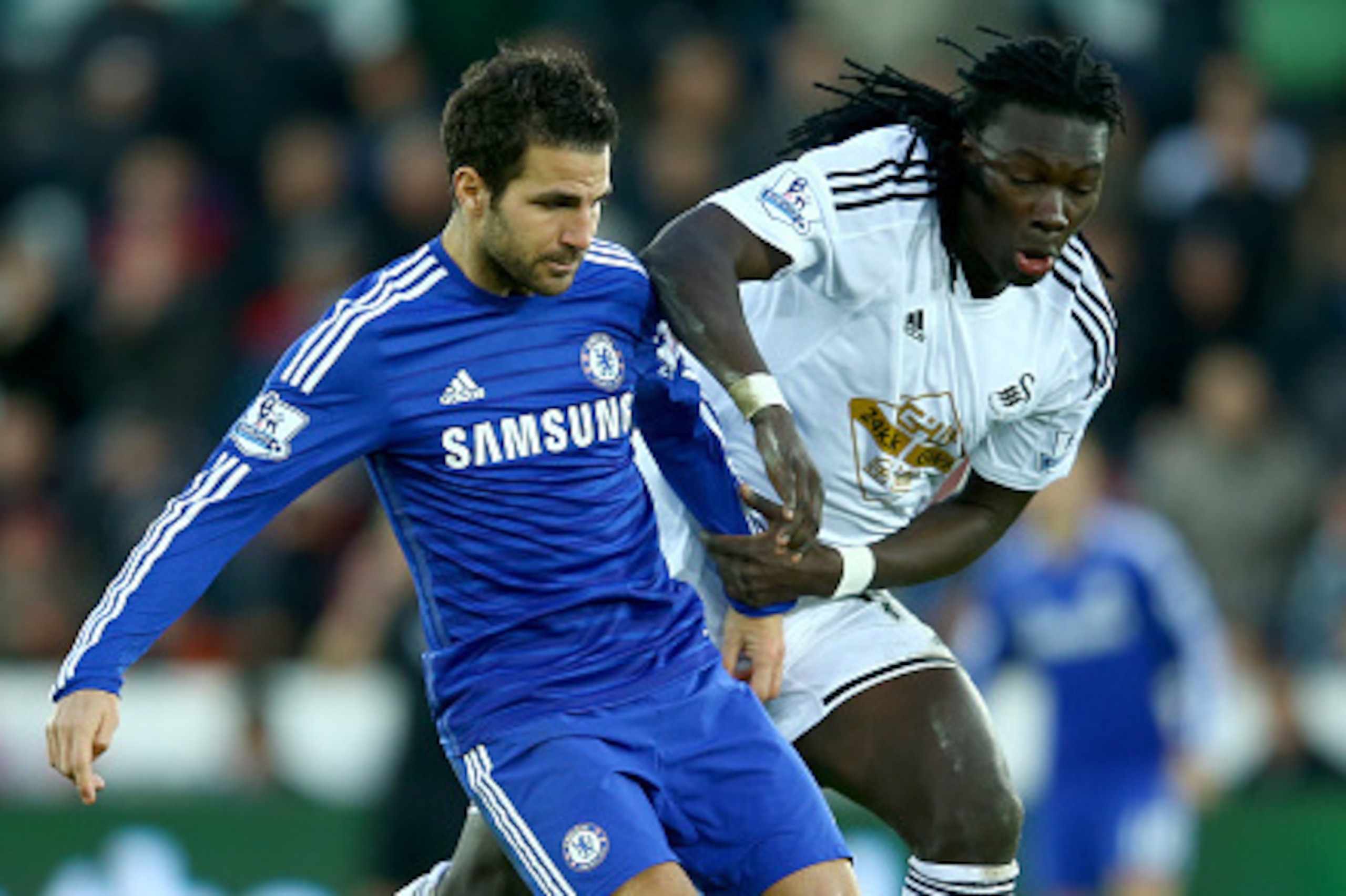 SWANSEA, WALES - JANUARY 17:  Cesc Fabregas of Chelsea holds off  Marvin Emnes of Swansea during the Barclays Premier League match between Swansea City and Chelsea at the Liberty Stadium on January 17, 2015 in Swansea, Wales.  (Photo by Richard Heathcote/