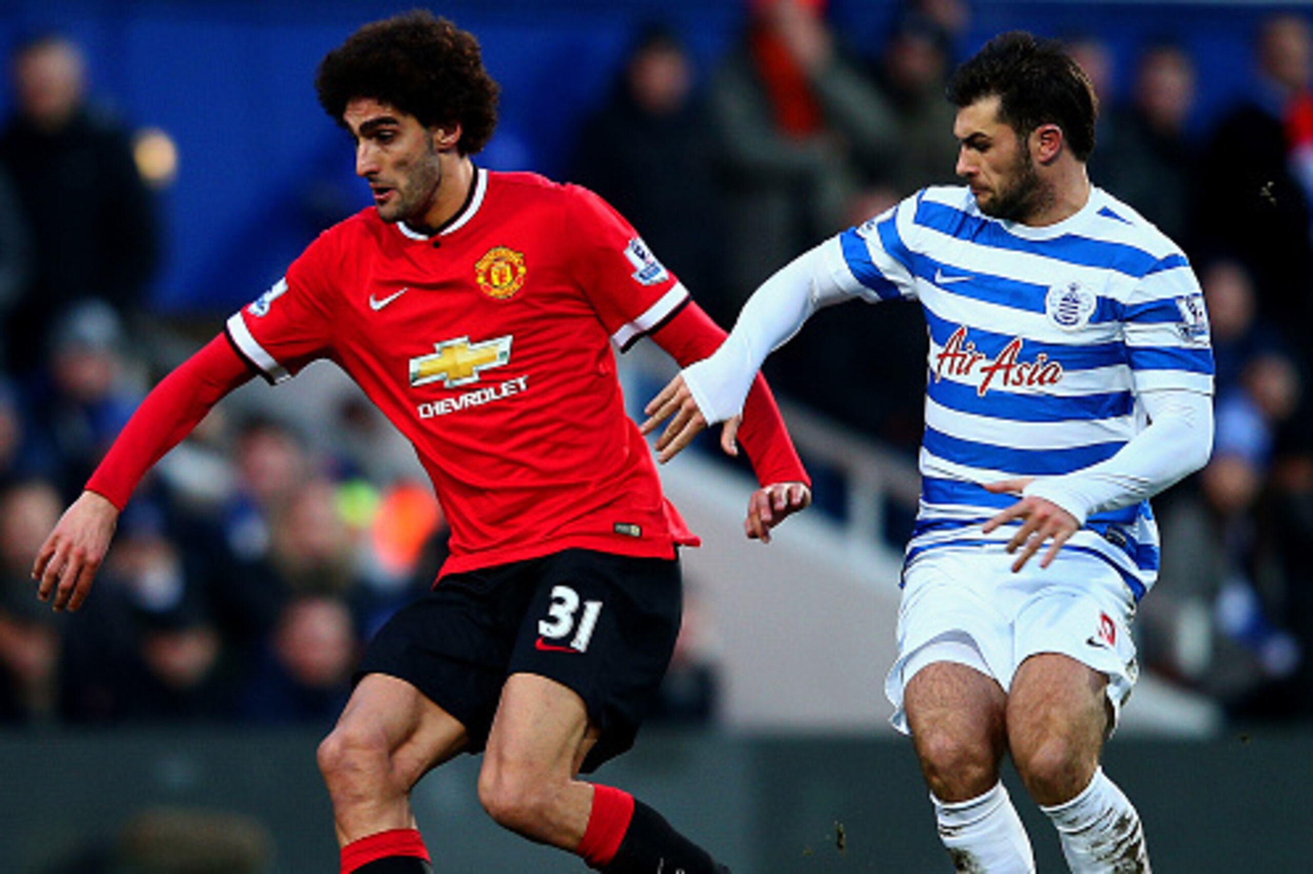 LONDON, ENGLAND - JANUARY 17:  Marouane Fellaini of Manchester United shields the ball from Charlie Austin of QPR during the Barclays Premier League match between Queens Park Rangers and Manchester United at Loftus Road on January 17, 2015 in London, Engl