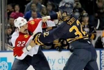 Feb. 3, 2013; Buffalo, NY, USA;  Florida Panthers right wing George Parros (22) and Buffalo Sabres left wing John Scott (32) fight during the second period at First Niagara Center.  Mandatory Credit: Timothy T. Ludwig-USA TODAY Sports