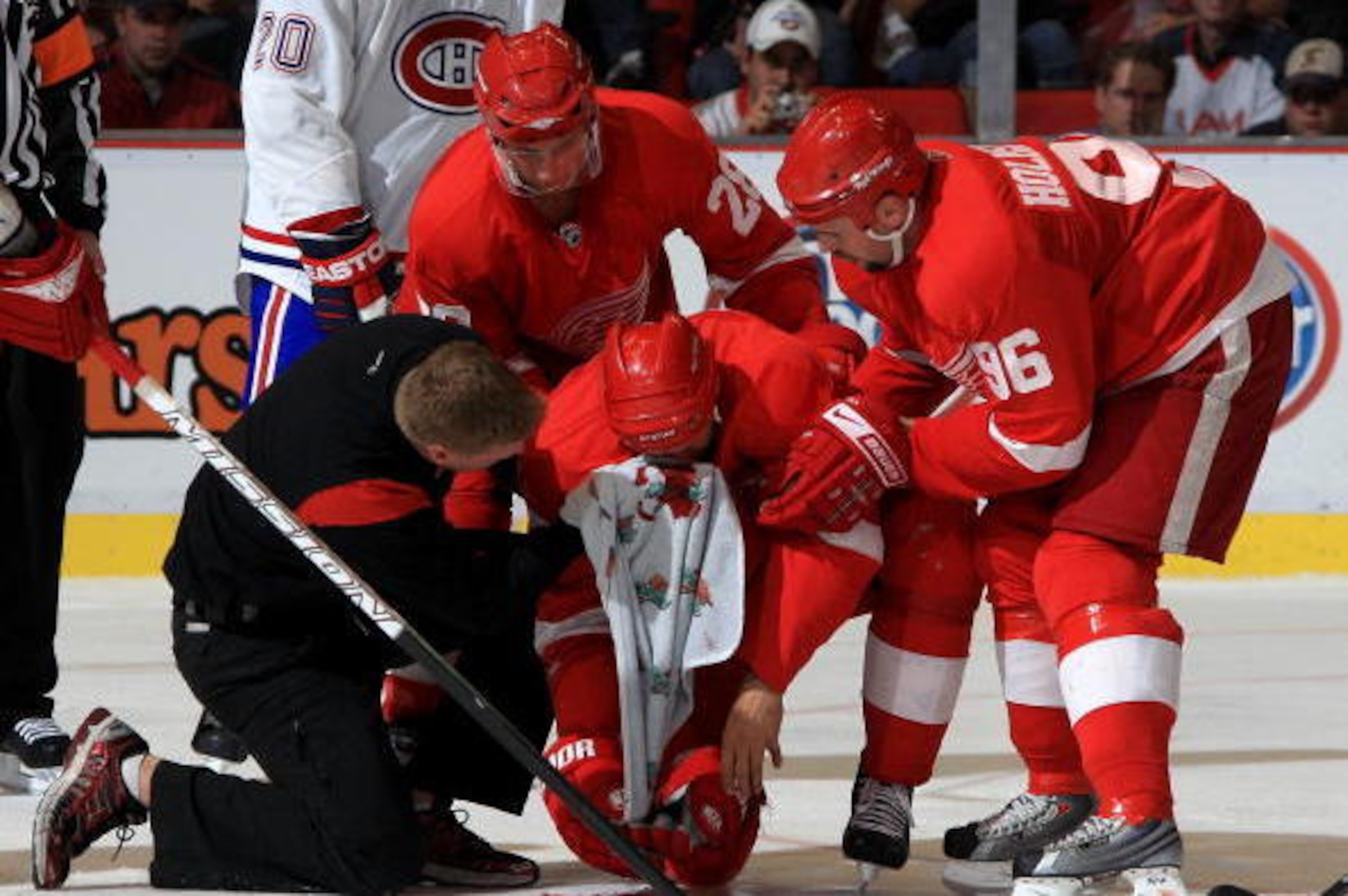 DETROIT - SEPTEMBER 24: Captain Nicklas Lidstom #5 of the Detroit Red Wings is helped off the ice by team trainer Piet Van Zant, Brian Rafalski #28 and Tomas Holmstrom #96 after being hit in the face with a puck during the NHL pre-season opener against t DETROIT - SEPTEMBER 24: Captain Nicklas Lidstom #5 of the Detroit Red Wings is helped off the ice by team trainer Piet Van Zant, Brian Rafalski #28 and Tomas Holmstrom #96 after being hit in the face with a puck during the NHL pre-season opener against t