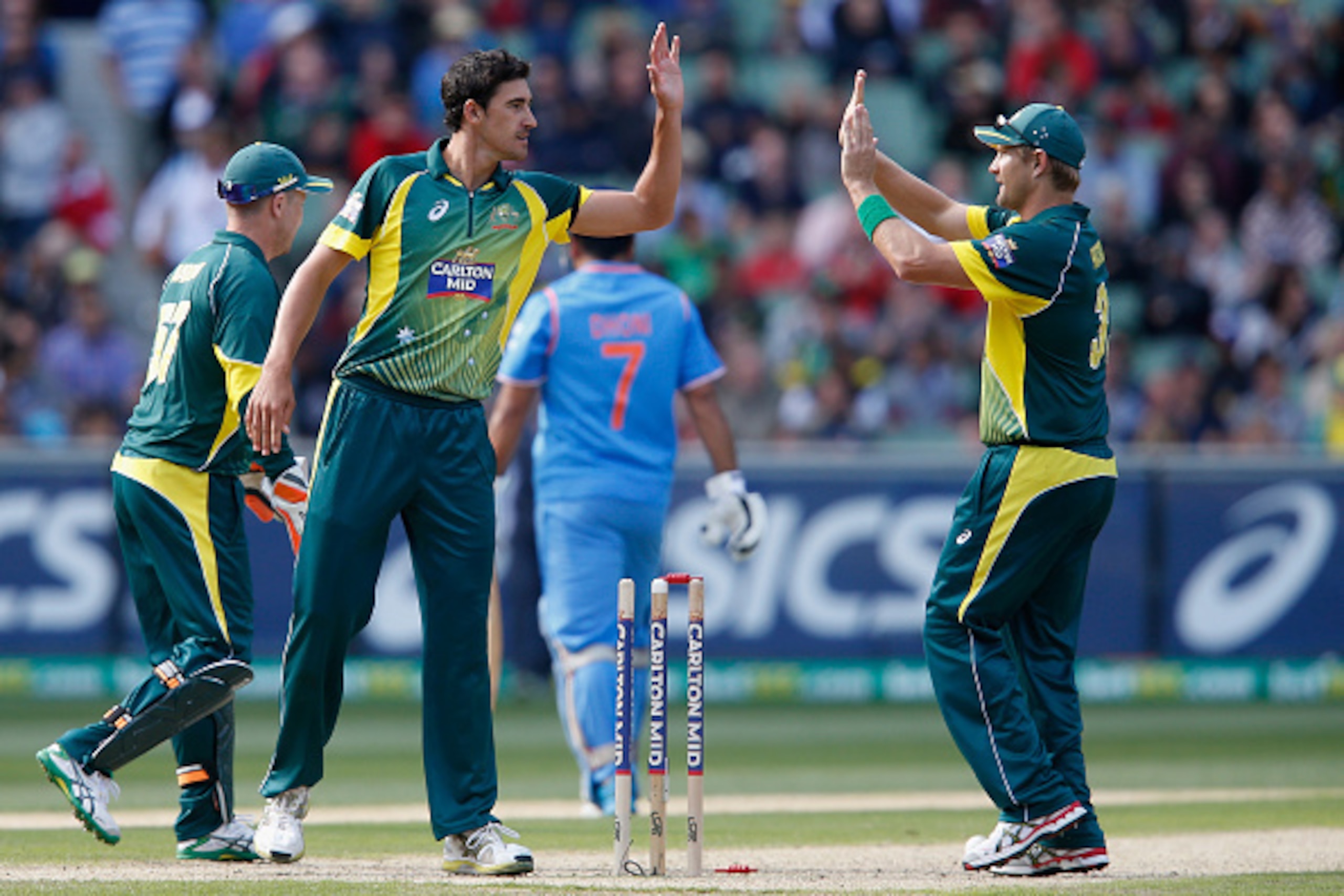 MELBOURNE, AUSTRALIA - JANUARY 18:  Mitchell Starc and Shane Watson of Australia  celebrates taking the wicket of MS Dhoni of India during the One Day International match between Australia and India at Melbourne Cricket Ground on January 18, 2015 in Melbo