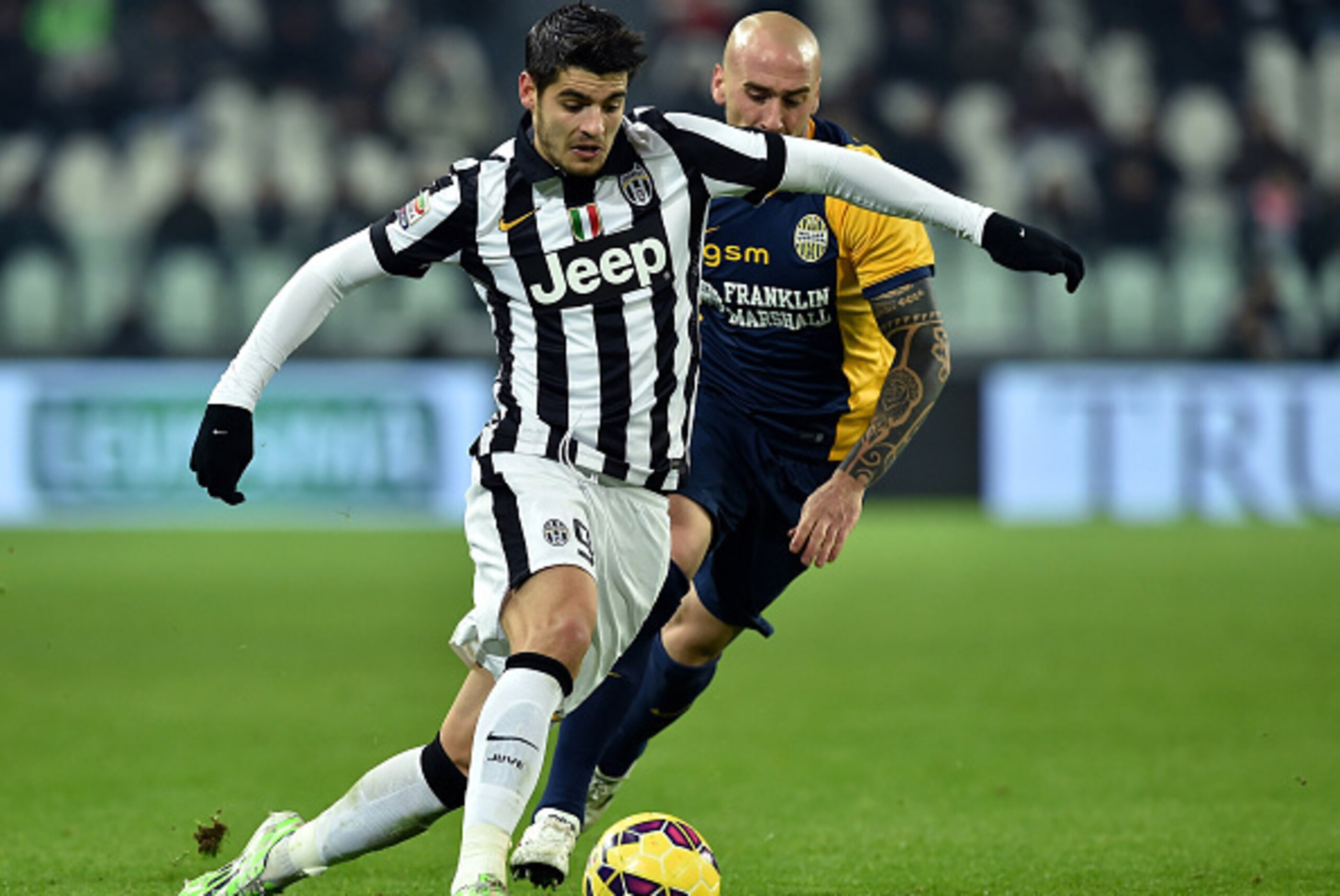 TURIN, ITALY - JANUARY 18:  Alvaro Morata (L) of Juventus FC in action against Guillermo Rodriguez of Hellas Verona FC during the Serie A match between Juventus FC and Hellas Verona FC at Juventus Arena on January 18, 2015 in Turin, Italy.  (Photo by Vale